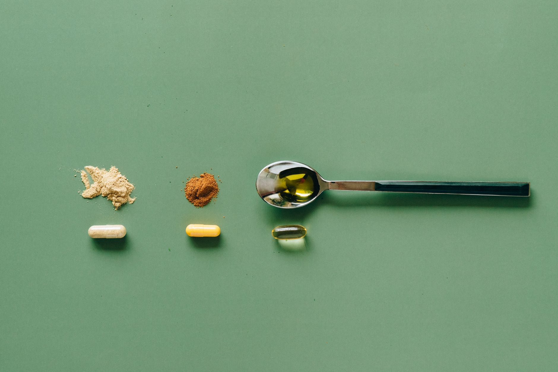 A close‑up of a hand measuring half a teaspoon of ground turmeric with a small spoon, illustrating the safe amount for pregnant individuals
