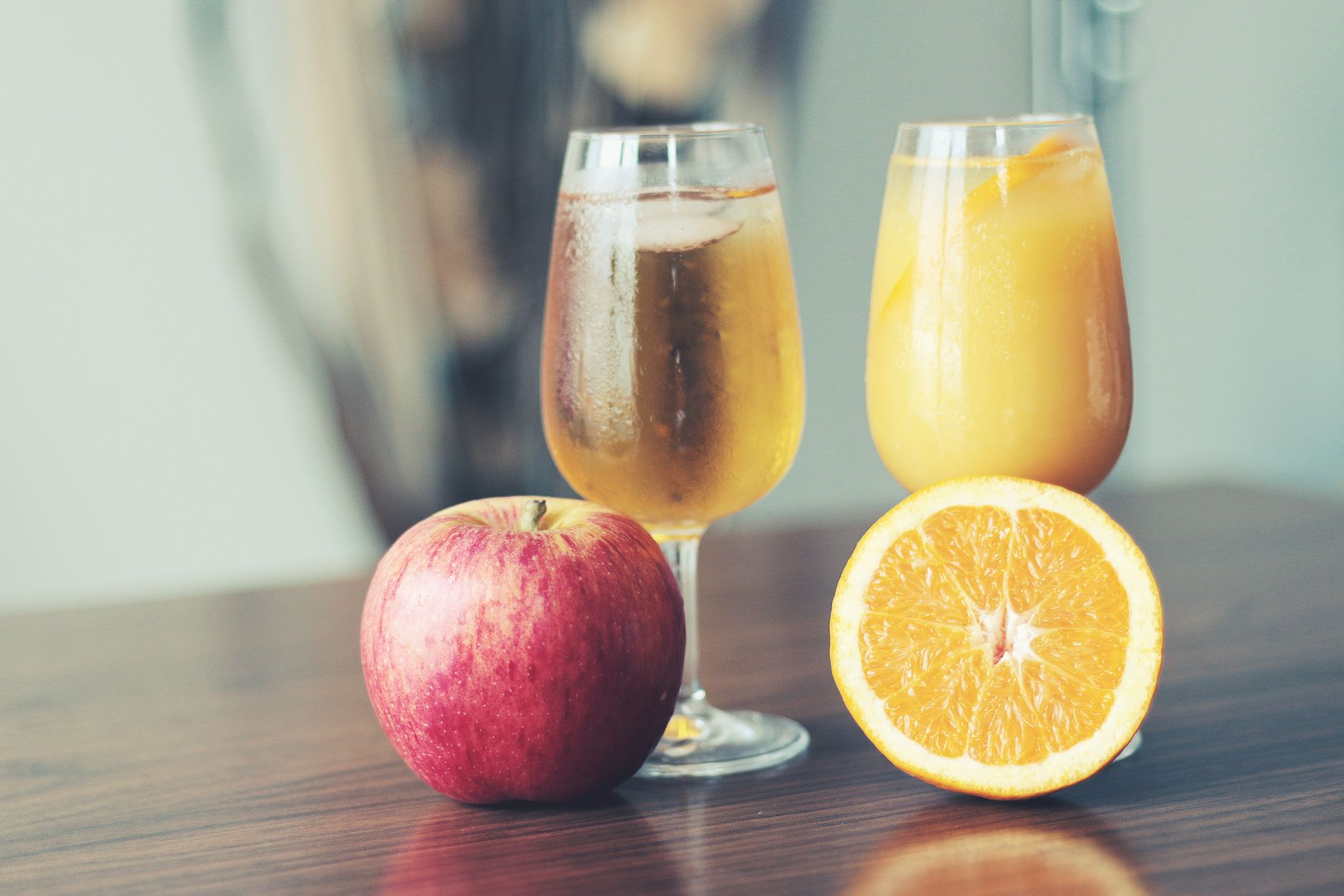 A glass of sparkling apple cider from Martinelli's on a brunch table with fresh apple slices, emphasizing a pregnancy‑safe alternative to hard cider