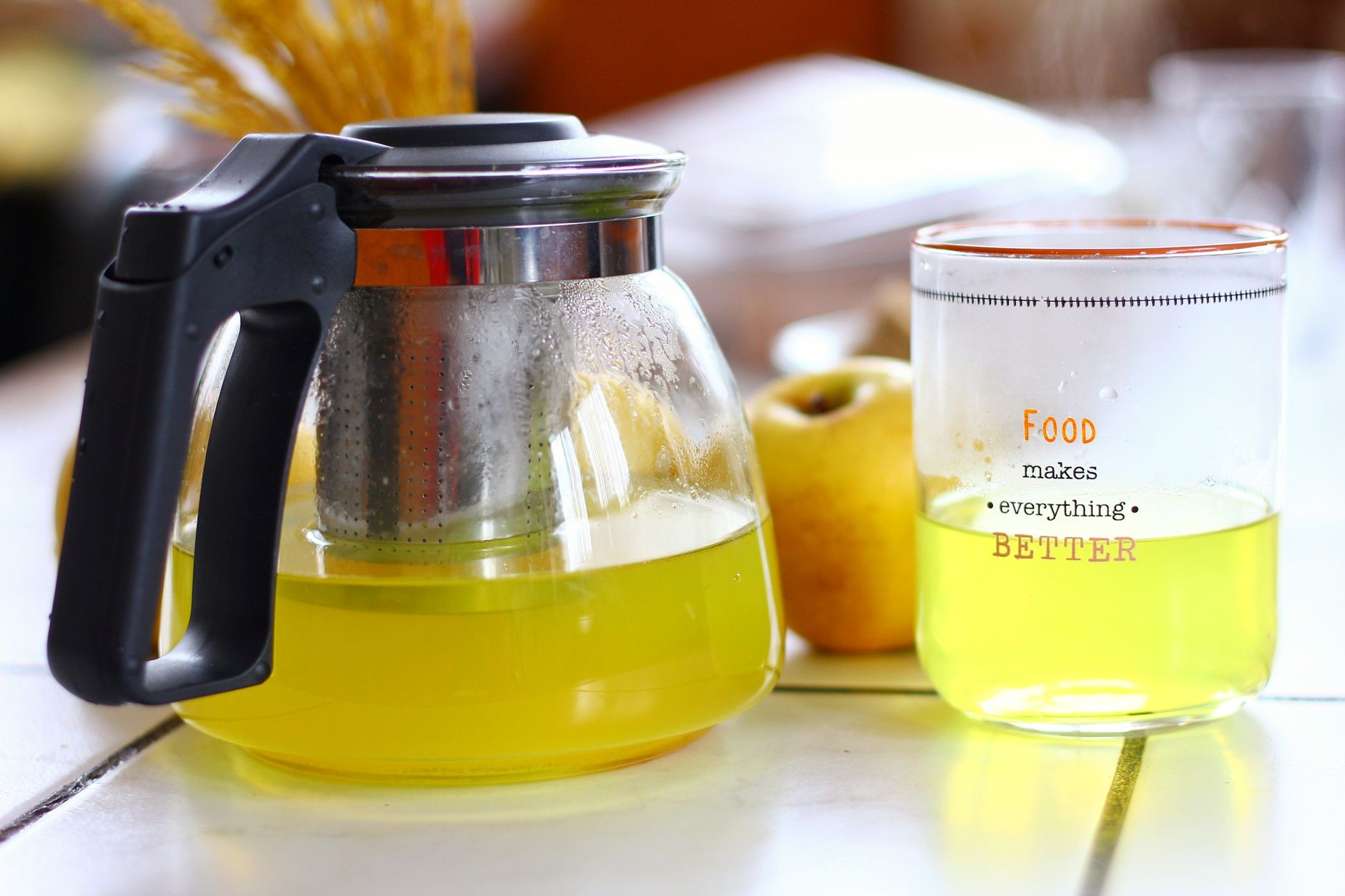 a tidy kitchen counter displaying ginger tea, chamomile tea, a glass of alkaline water, and a small bottle of apple cider vinegar, emphasizing natural heartburn remedies for pregnant women