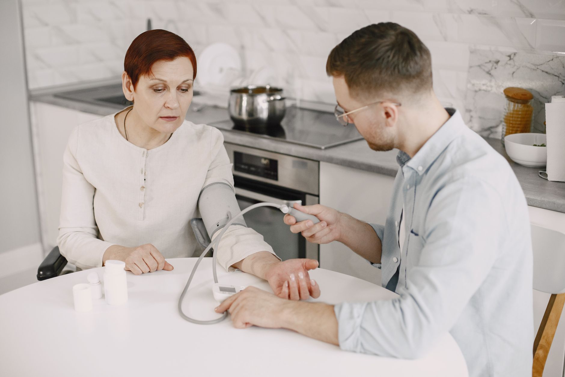 pregnant woman holding a blood pressure cuff while looking at a prenatal chart, soft indoor lighting, emphasizing monitoring, 1200x675