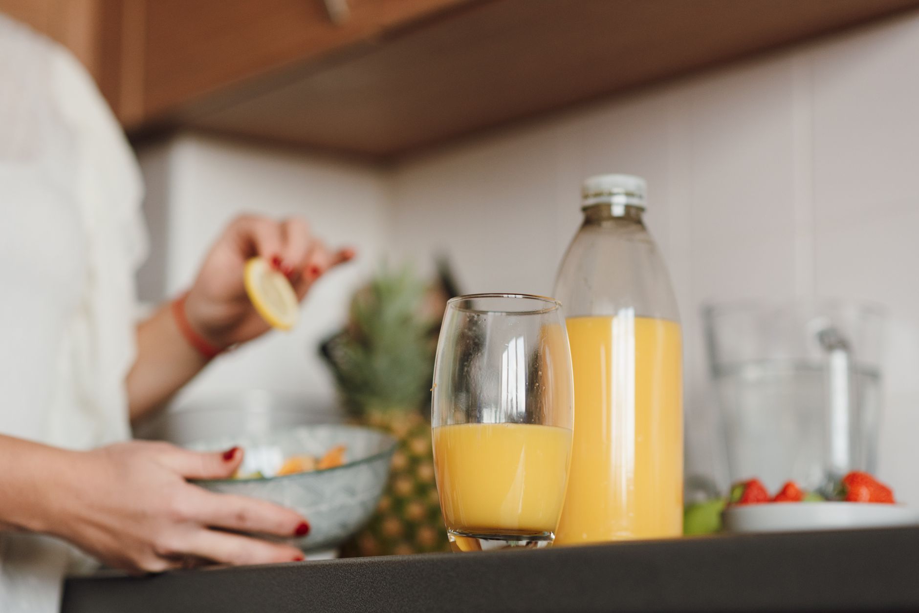 a calming scene of a pregnant woman sipping orange juice while holding a prenatal vitamin bottle, illustrating iron with vitamin C, 80-120 characters