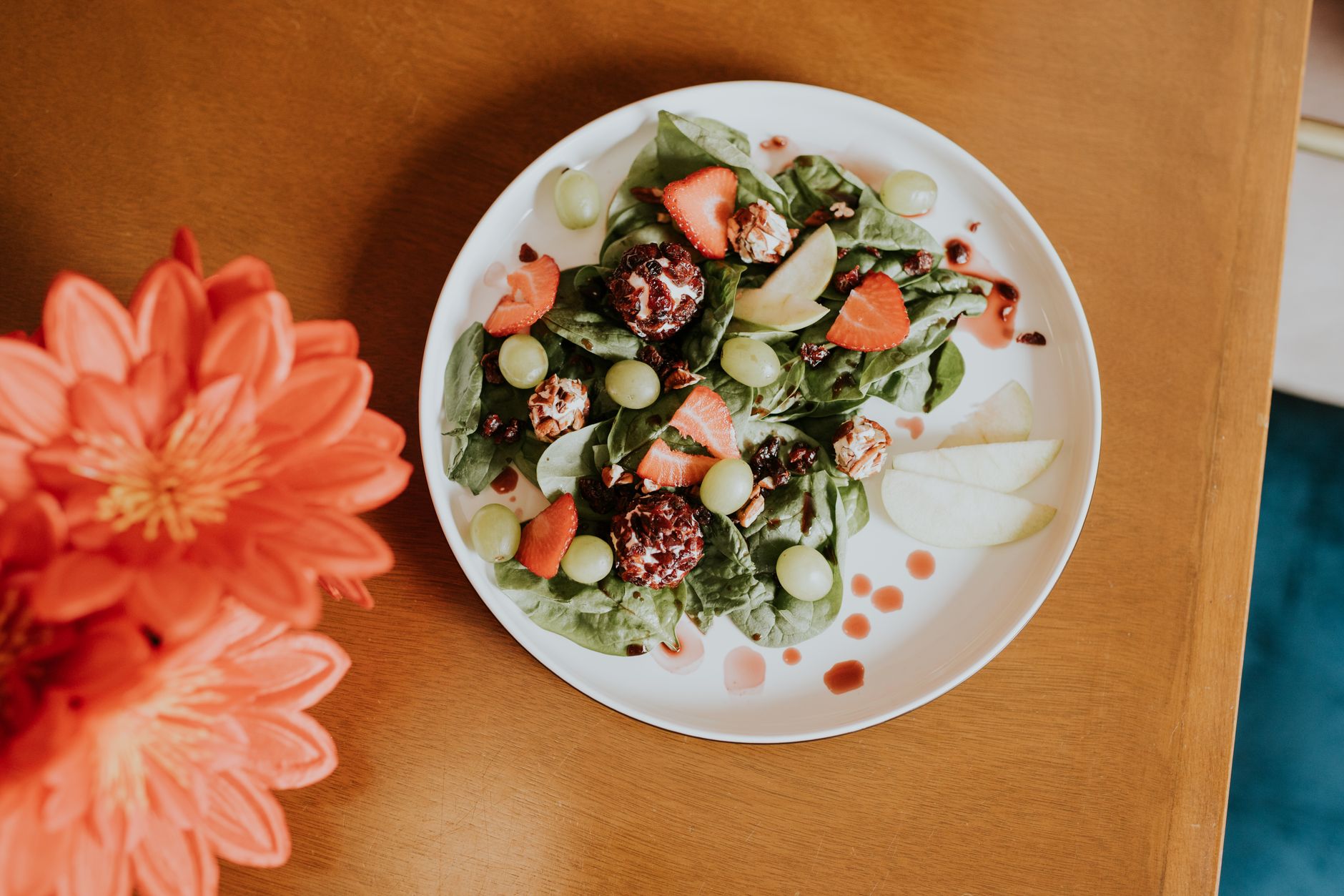 a wholesome iron-rich spinach salad with strawberries and orange slices, highlighting iron and vitamin C together for better absorption, 80-120 characters