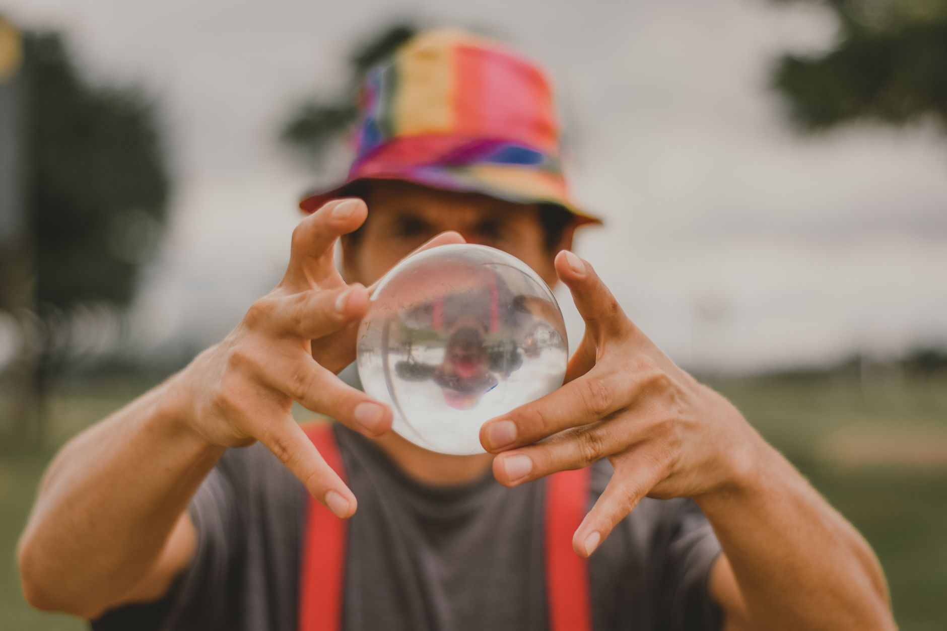 close-up of hands holding three soft juggling balls against a neutral background