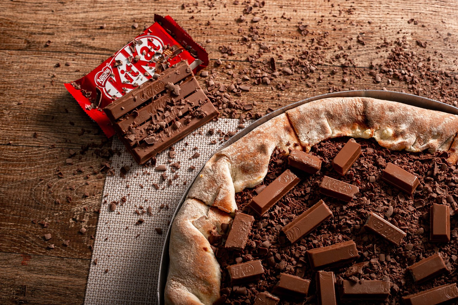 a tray of dark chocolate Kit Kat bars next to a bowl of fresh berries, illustrating a balanced snack option for pregnant individuals