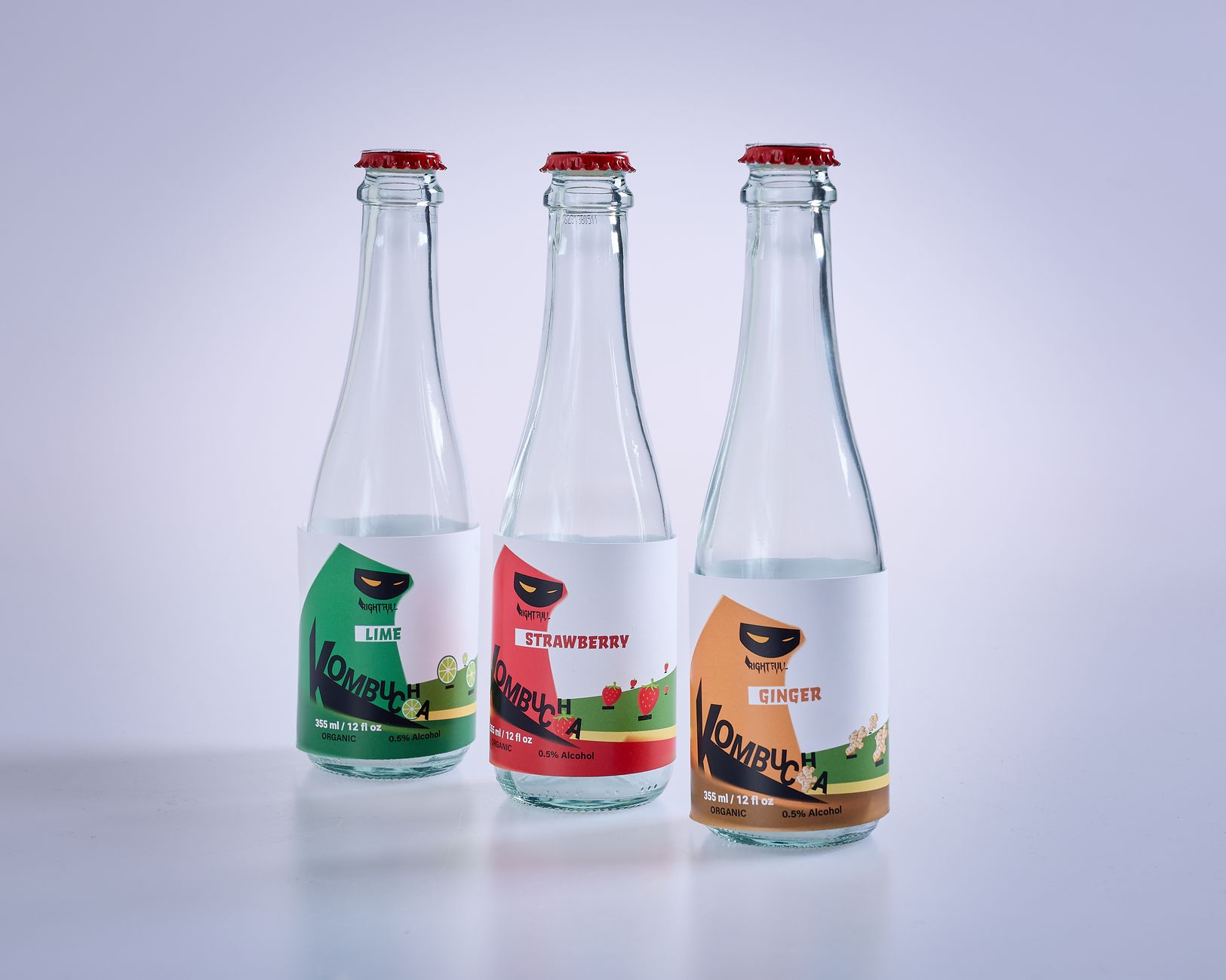 A selection of low‑alcohol kombucha bottles arranged on a wooden tray, each labeled with alcohol percentage and caffeine content for easy pregnancy‑friendly comparison