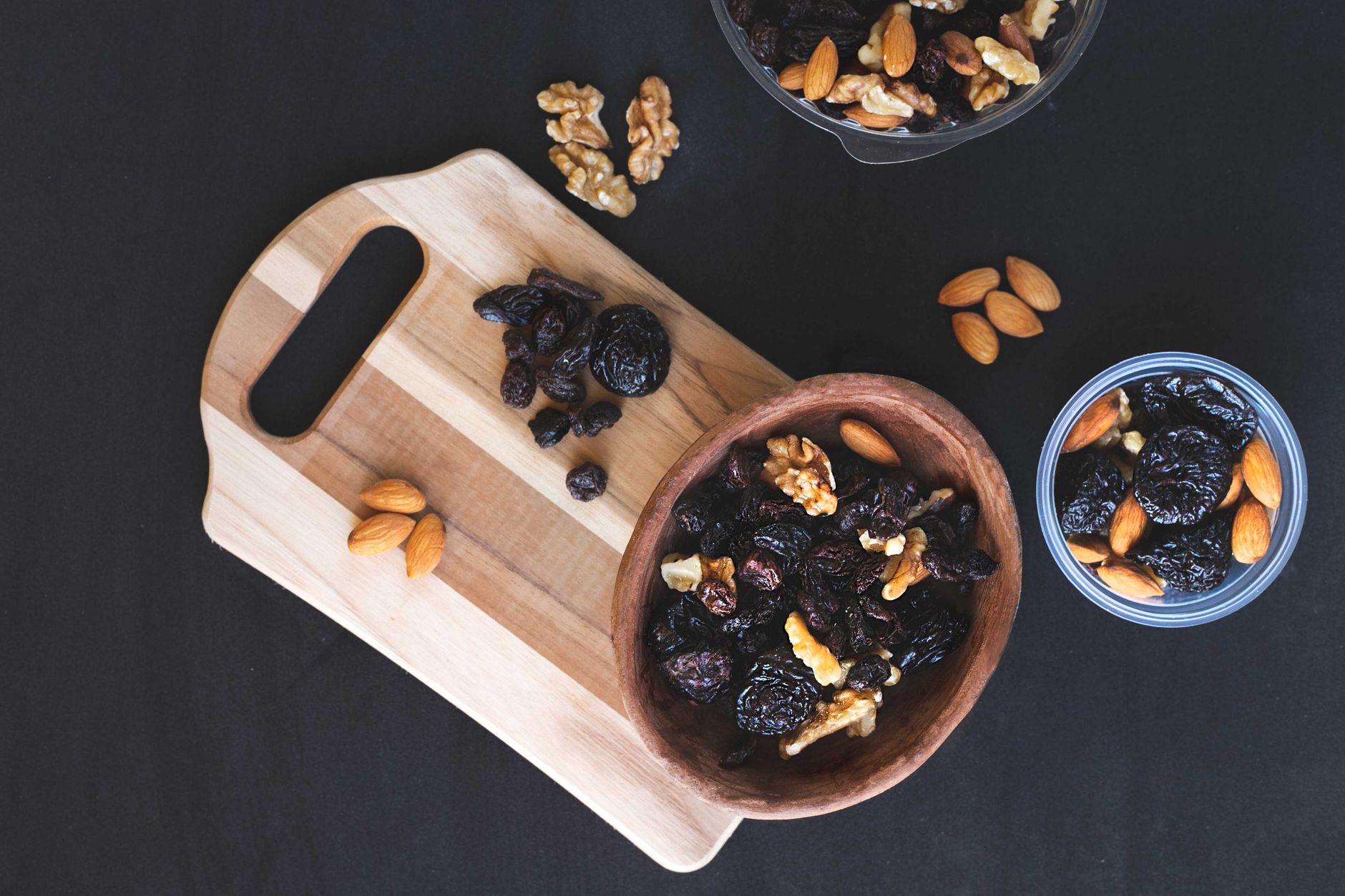 A colorful assortment of pregnancy‑safe snack alternatives, including baked sweet potato chips, kale chips, popcorn, carrot sticks, and apple slices, arranged on a wooden board