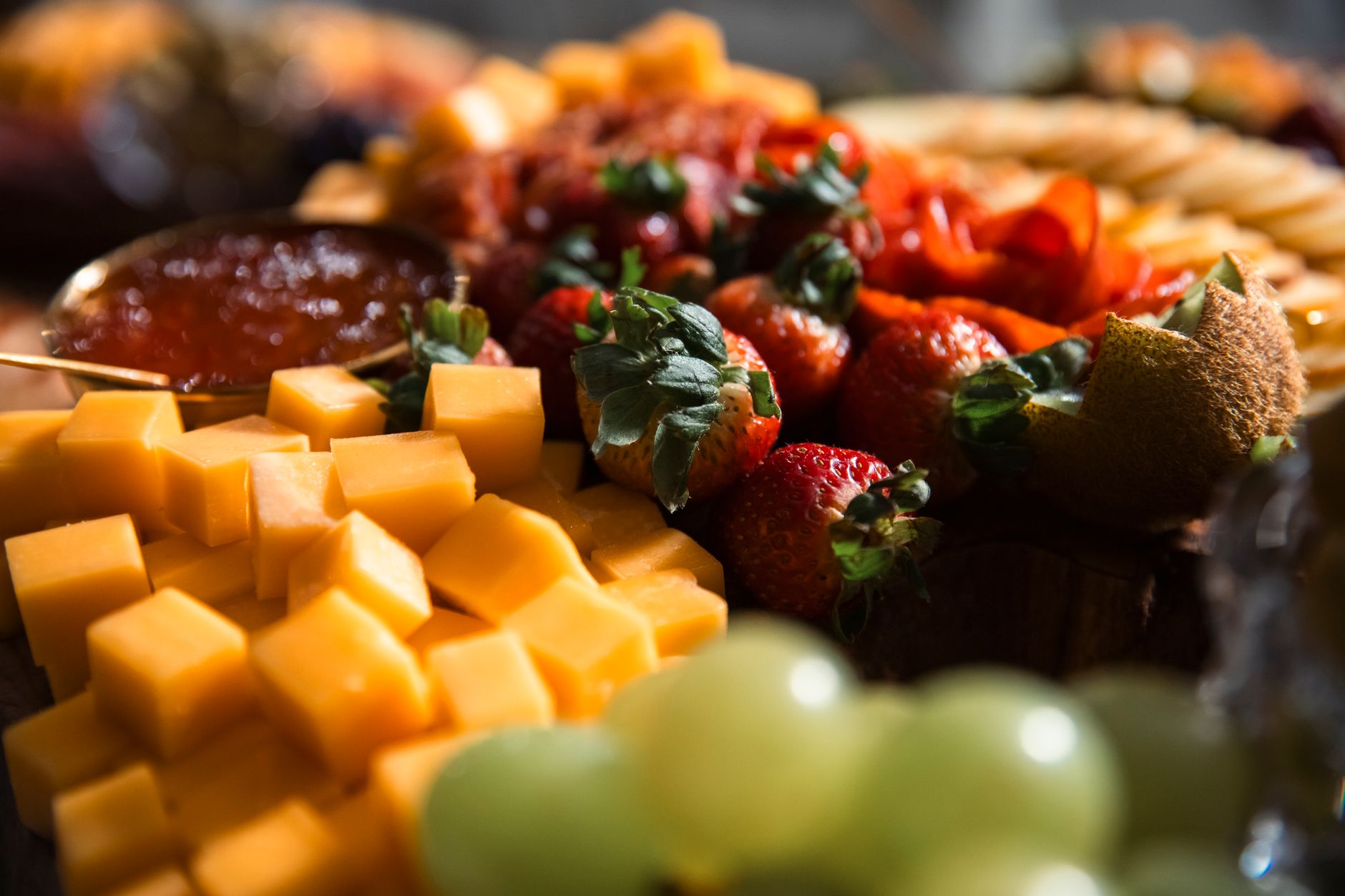 A vibrant spread of pregnancy-safe foods including hard cheeses, cooked chicken salad, fresh berries, cooked vegetables, and pasteurized yogurt