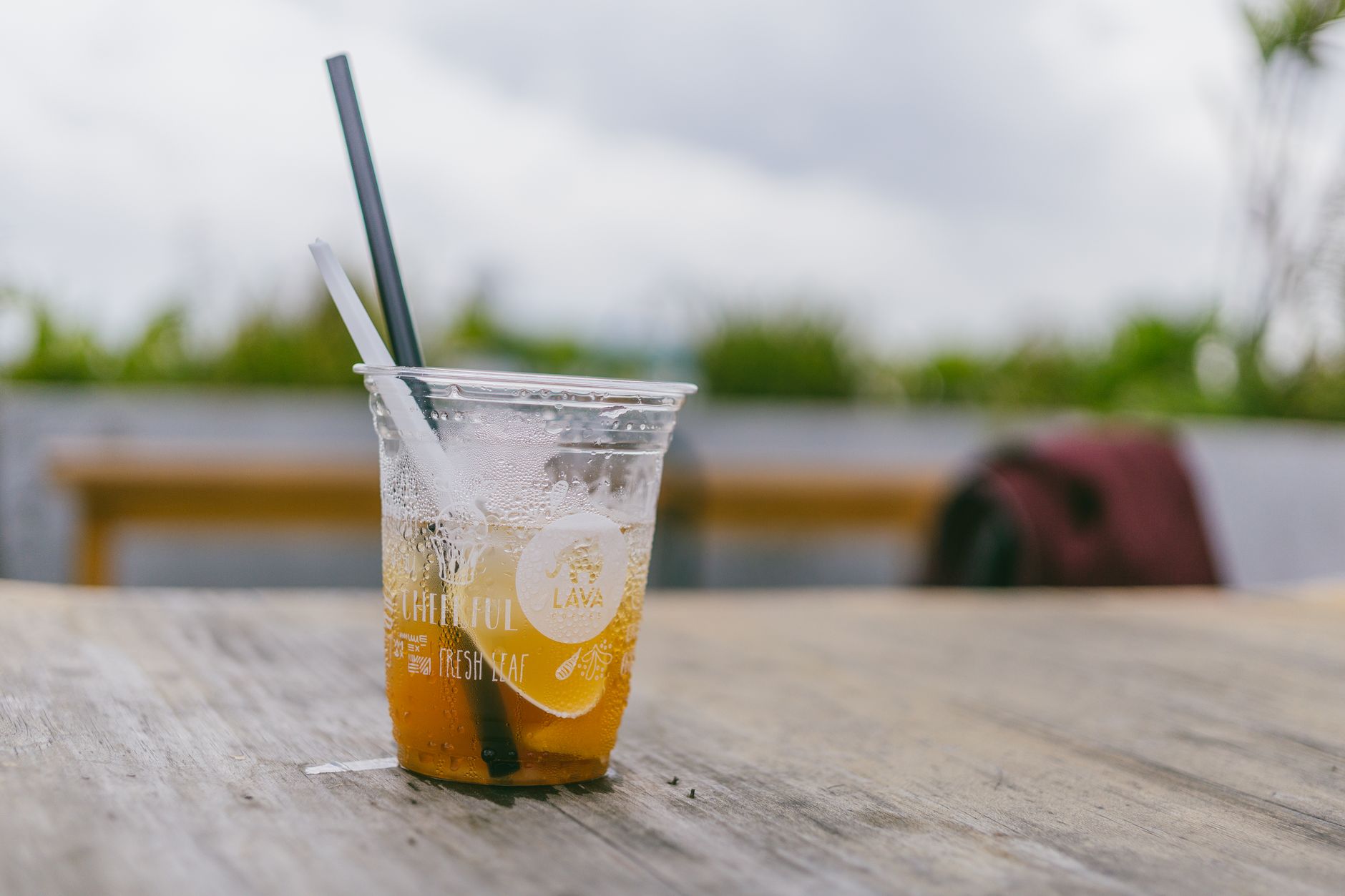A McDonald's unsweetened iced tea cup next to a bottle of water on a clean table, emphasizing healthier drink choices.