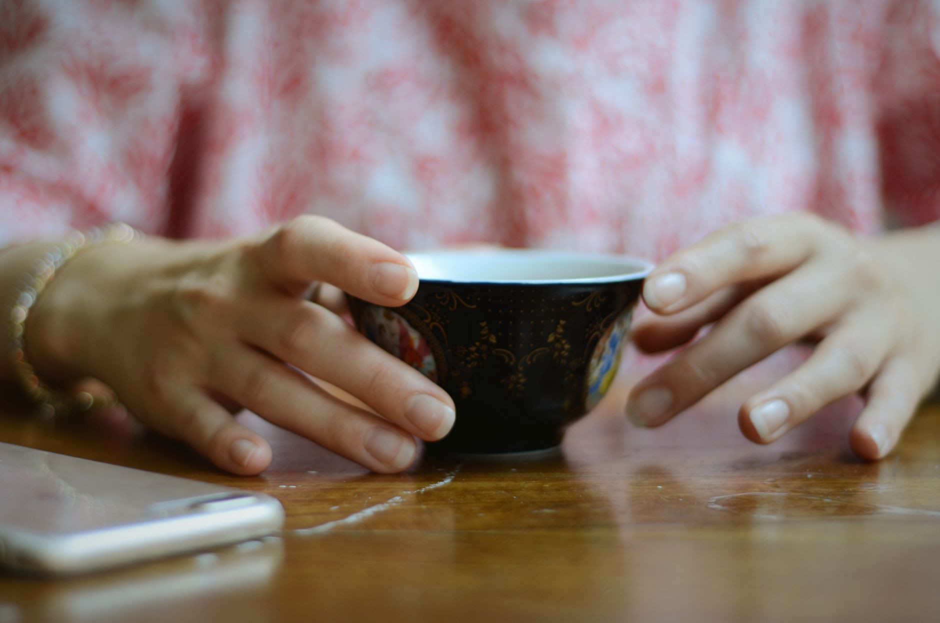 a pregnant woman holding a ginger tea mug while looking at a travel itinerary, soft light, emphasizing safe travel nausea relief options