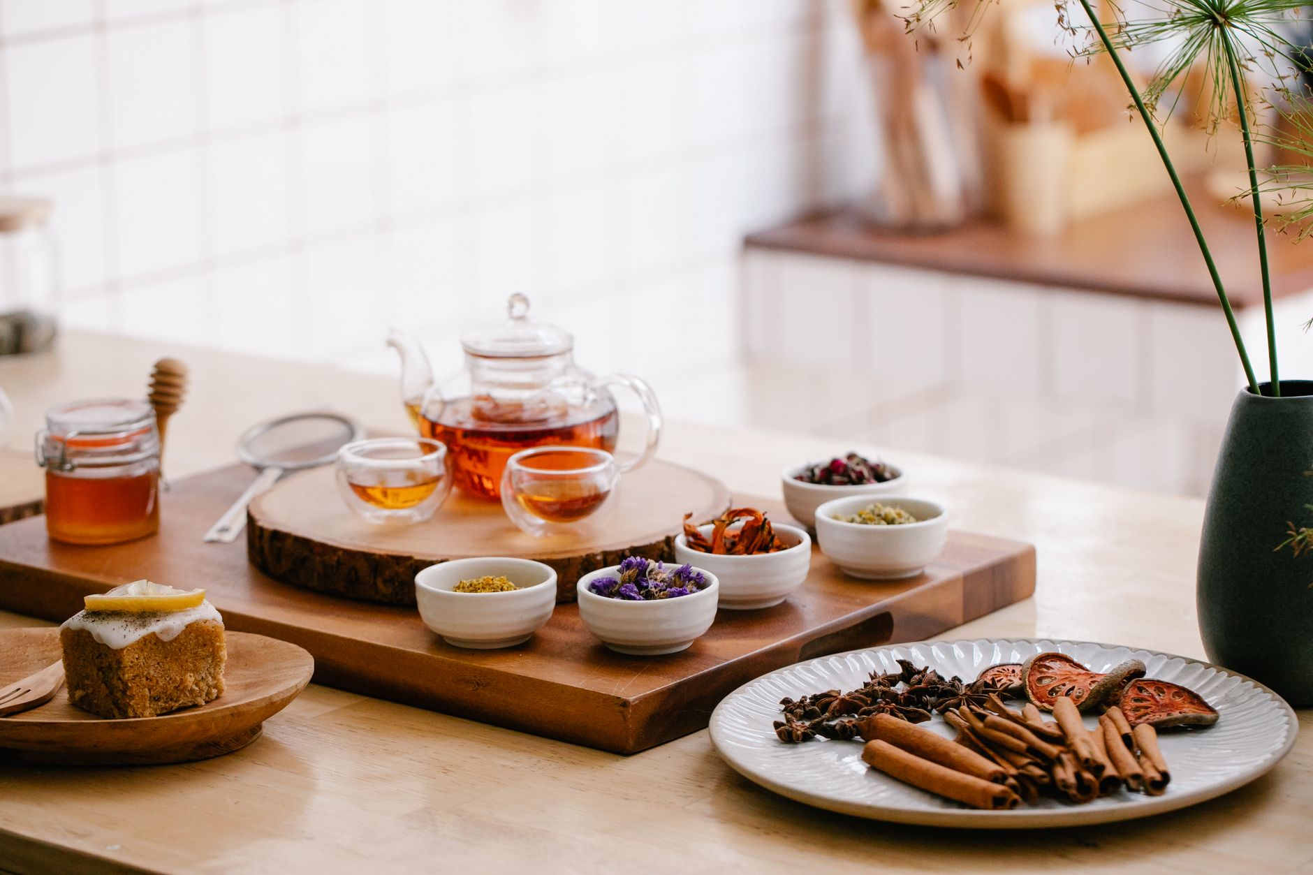 a selection of throat lozenges, a honey jar, and a steaming mug of tea on a kitchen counter, representing natural sore throat remedies for pregnant women