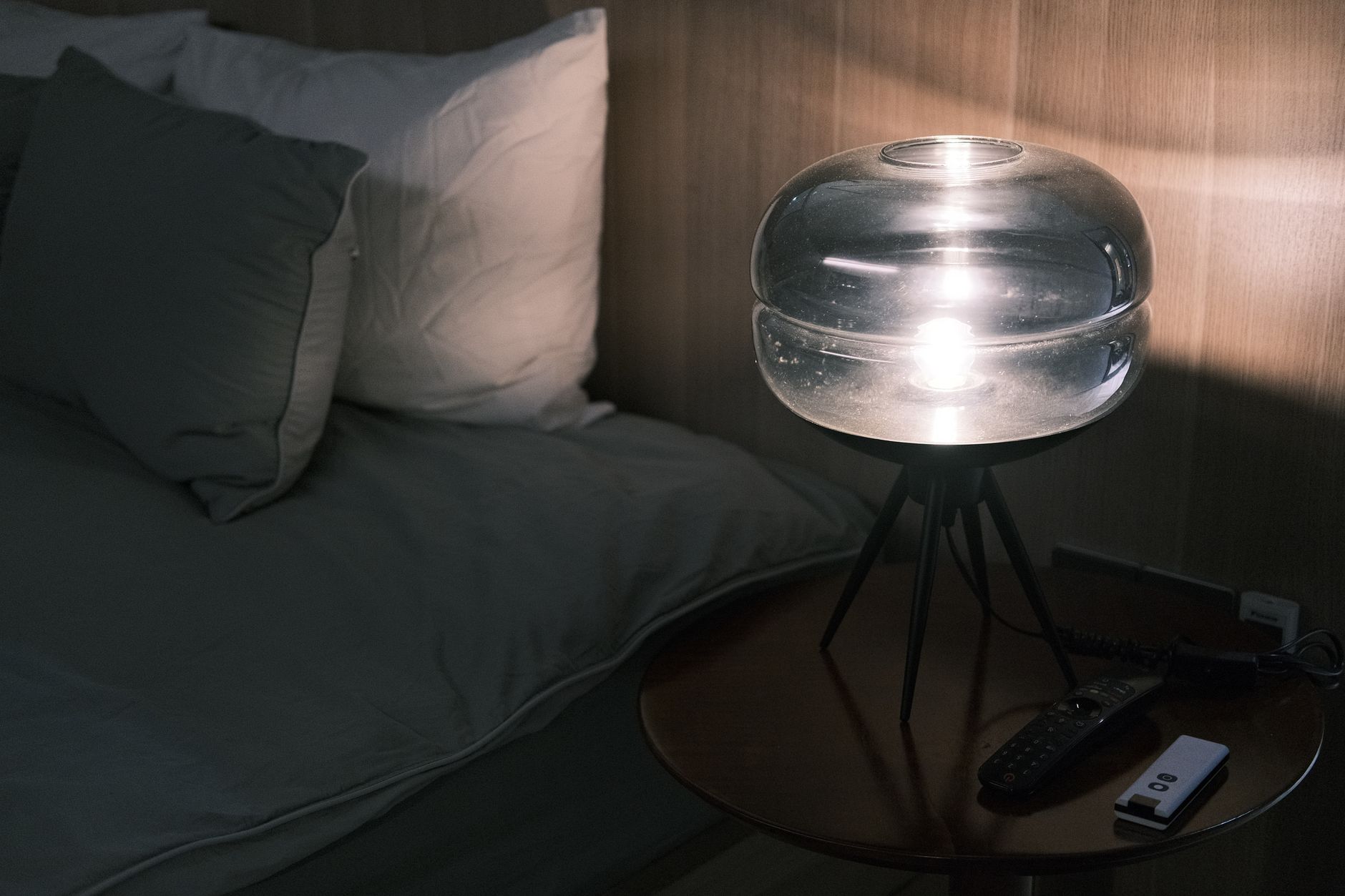 A cozy bedroom scene with dimmed lights, a pregnancy pillow propped behind a sleeping expectant mother, a glass of warm milk on the nightstand, and a subtle aroma of chamomile in the air