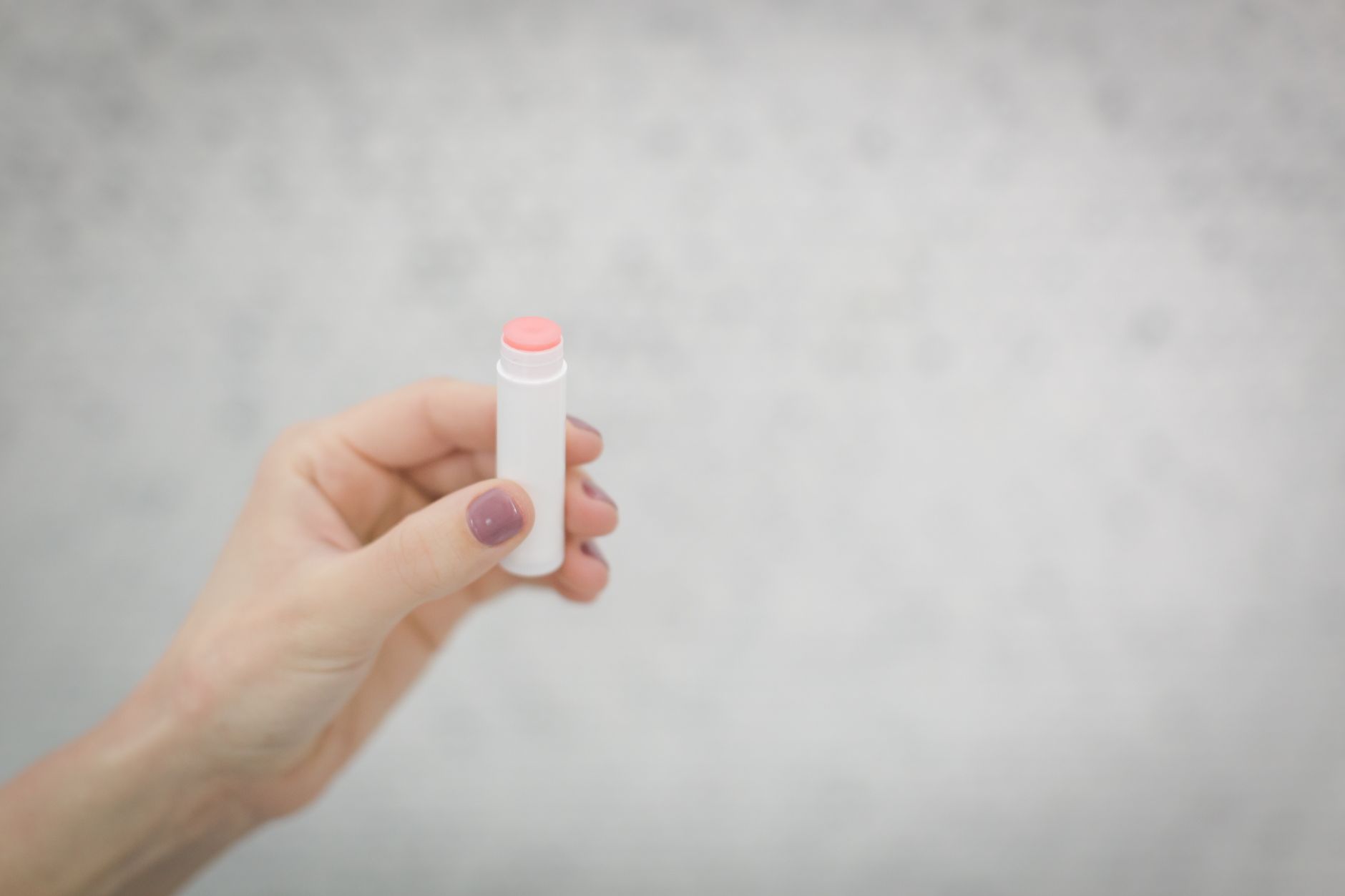 Close‑up of a pregnant woman's hand applying a soothing moisturizer after a microdermabrasion session, highlighting post‑treatment care