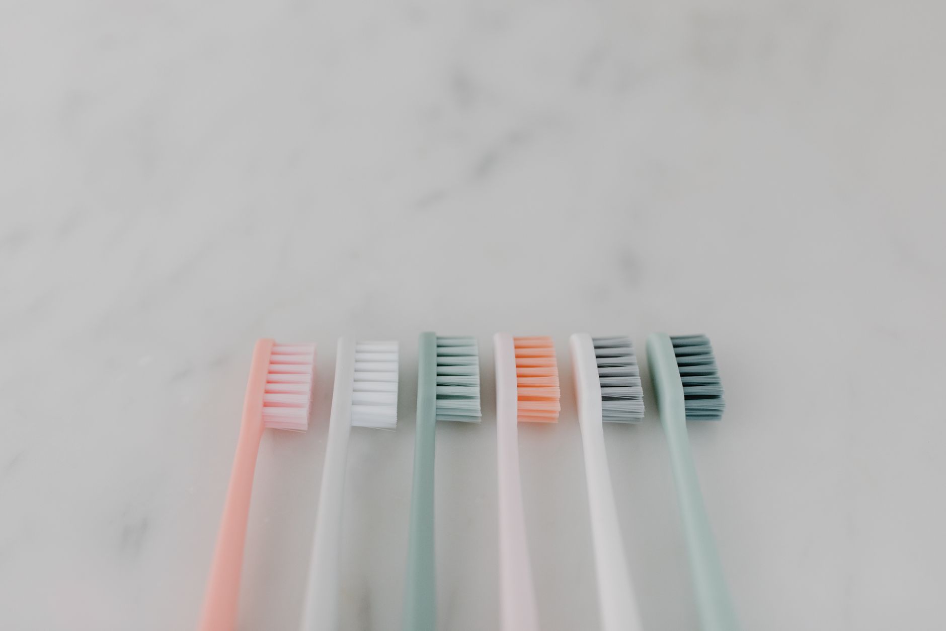 A dental care kit for pregnant women featuring a toothbrush, floss, and an alcohol‑free mouthwash, arranged neatly on a pastel background