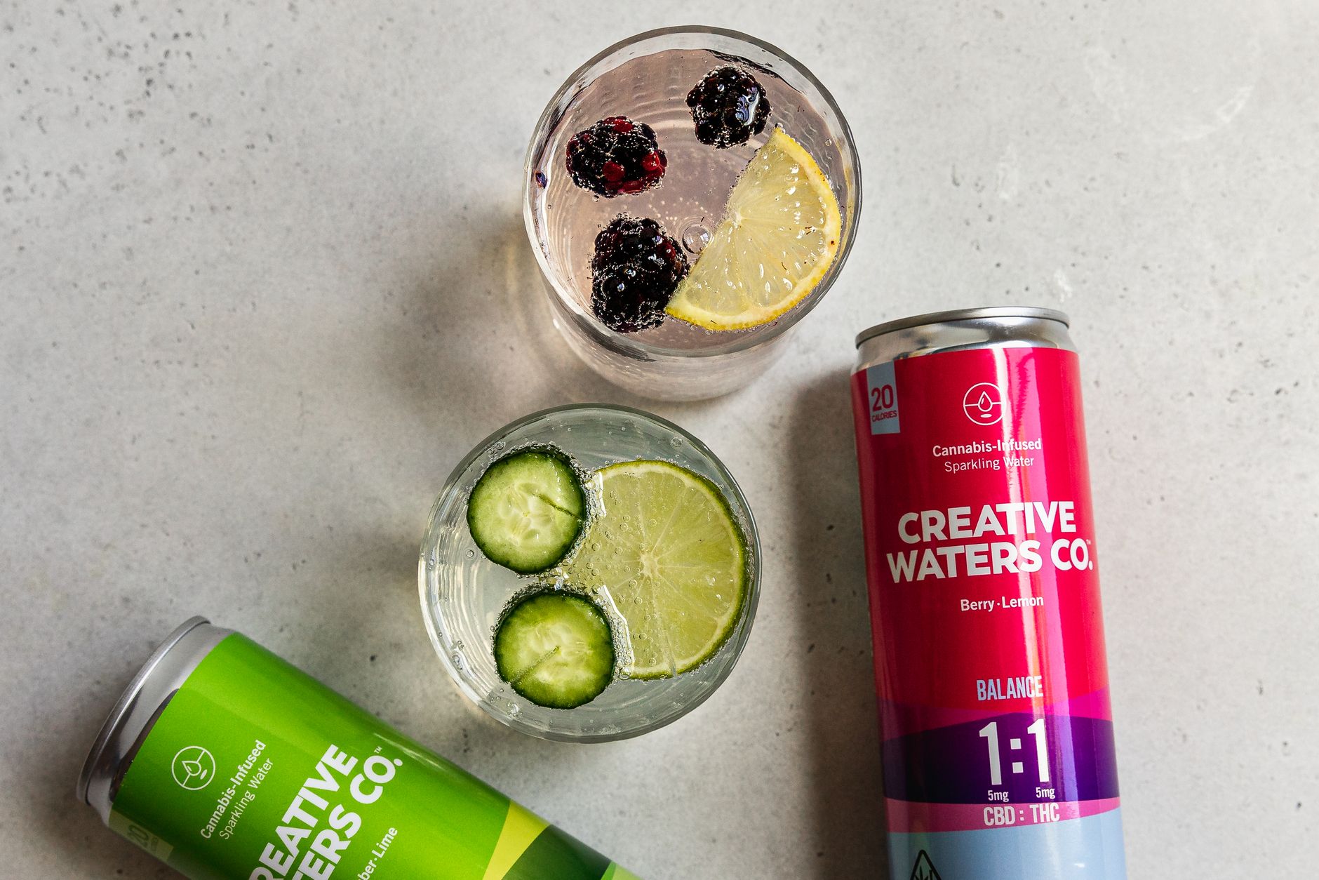 a glass of sparkling water with cucumber slices alongside a Heineken Zero can on a brunch table, bright morning light