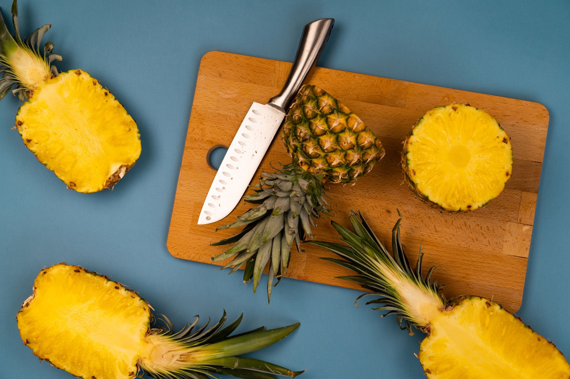 Close‑up of a ripe pineapple on a kitchen counter with a cutting board and knife, illustrating proper selection and preparation for pregnant women