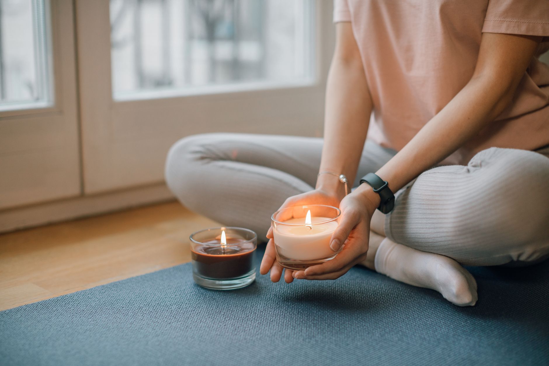 a tranquil yoga mat beside a small prayer candle and a cup of herbal tea, illustrating a combined prayer and prenatal yoga routine for expectant mothers