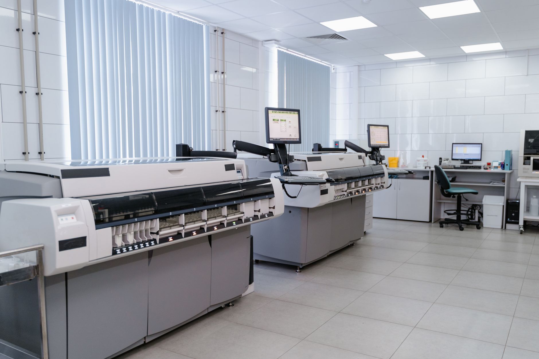 Well-ventilated print shop with large fans and open windows, showing modern digital printing equipment