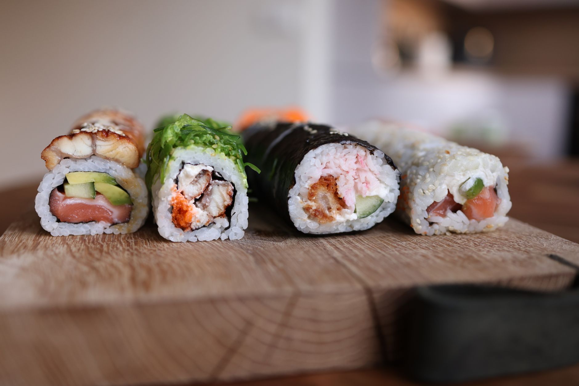 assorted sushi rolls on a wooden board, some with cooked shrimp tempura, others with raw salmon, bright colors, soft natural light highlighting freshness and safety labels