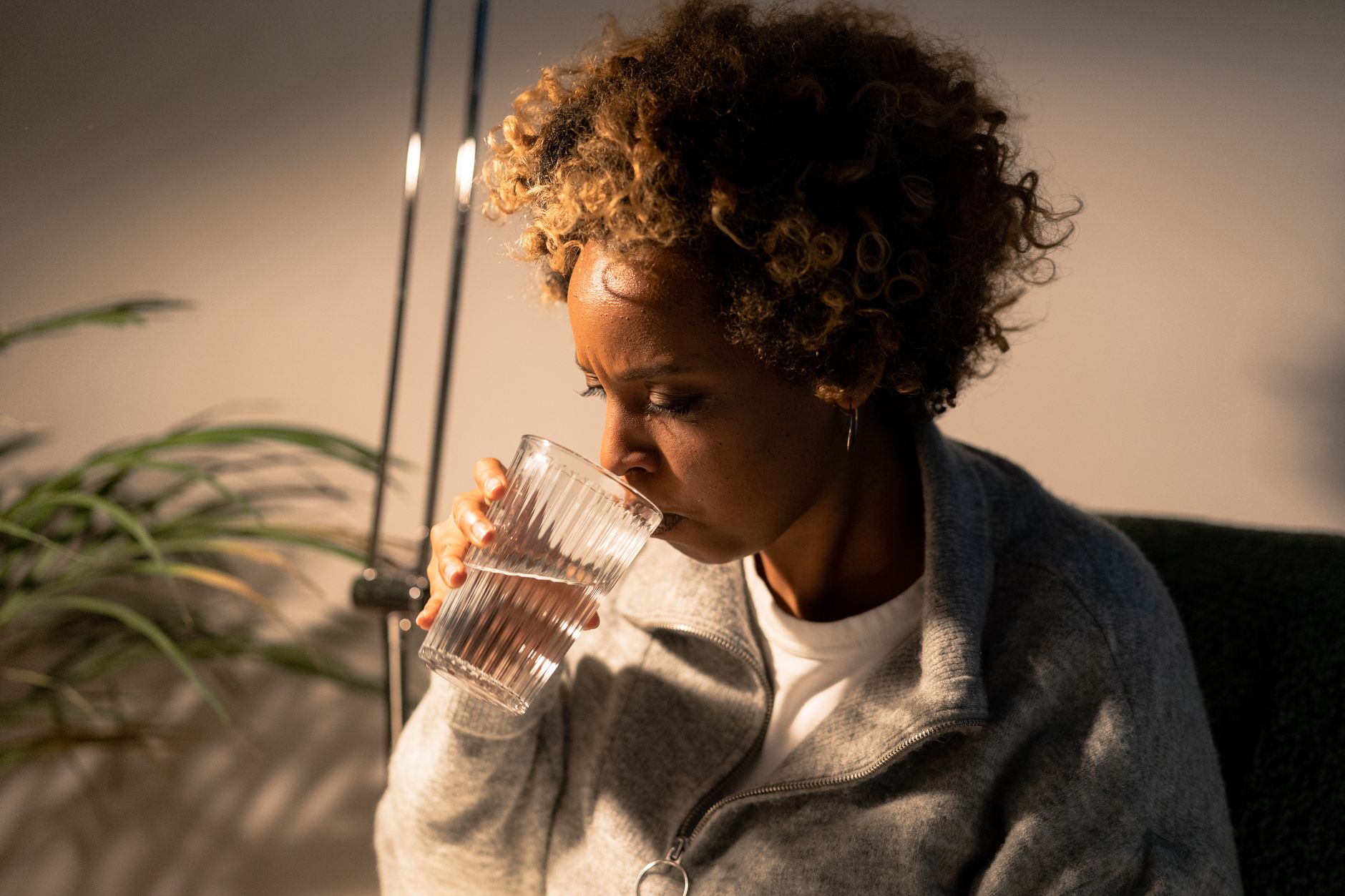 a calm kitchen scene with a pregnant woman holding a single Reese’s Peanut Butter Cup, soft daylight, a glass of water beside her, emphasizing mindful indulgence