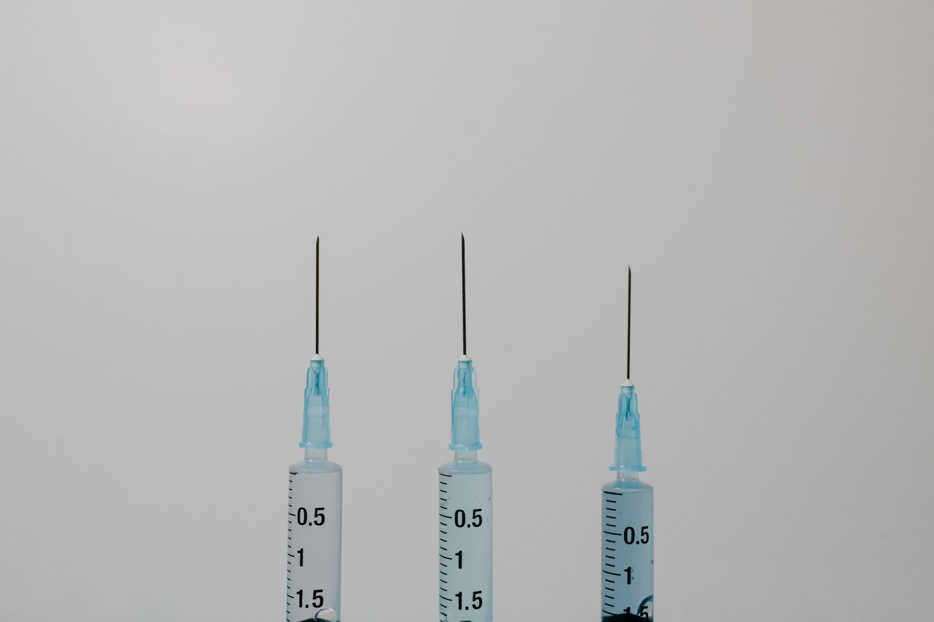 hospital pharmacy counter with labeled Veklury vials, a syringe, and a clipboard showing a dosage chart, bright natural light