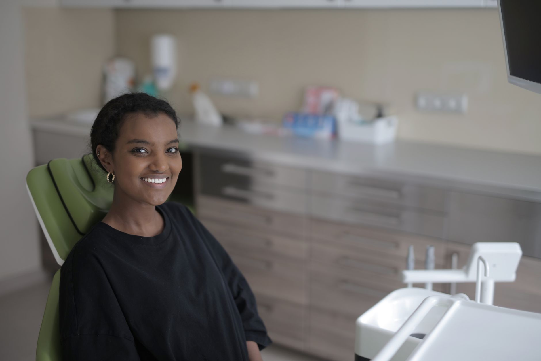 a calm dental office with a pregnant patient seated in a semi‑recumbent chair, a dentist holding a lidocaine cartridge, and a soft‑glow lamp providing a soothing environment