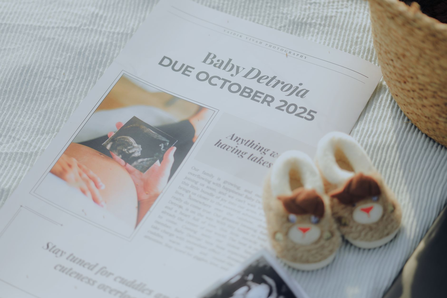 A pair of feet in pregnancy-safe walking shoes on a wooden floor with a pregnancy journal and a due date tracker