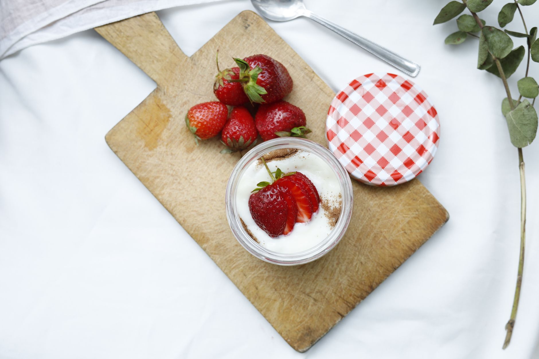 a spread of pregnancy-safe sweet alternatives including fresh strawberries, dark chocolate, and dried mango strips