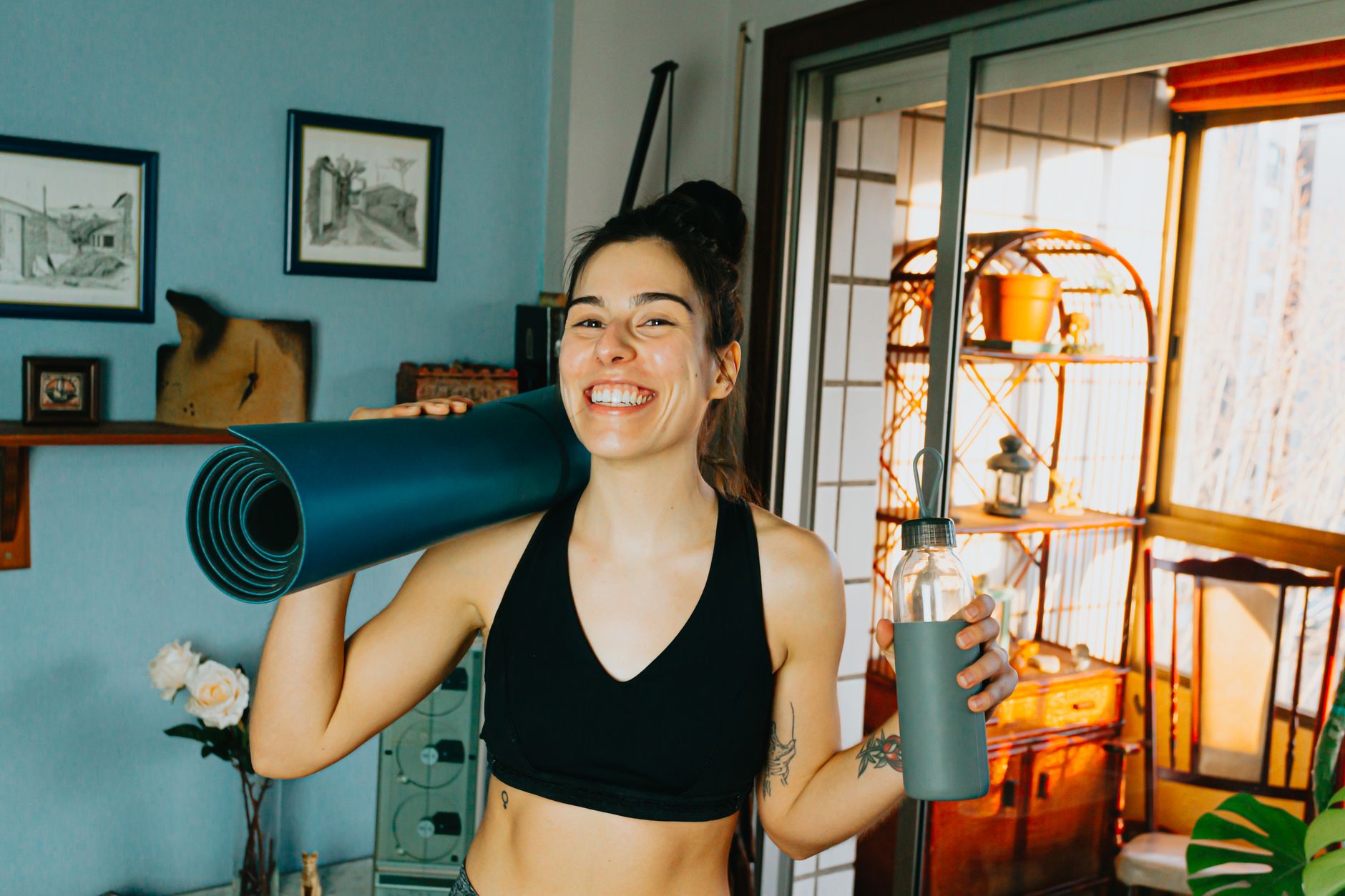 Pregnant woman adjusting her Peloton bike seat in a home gym