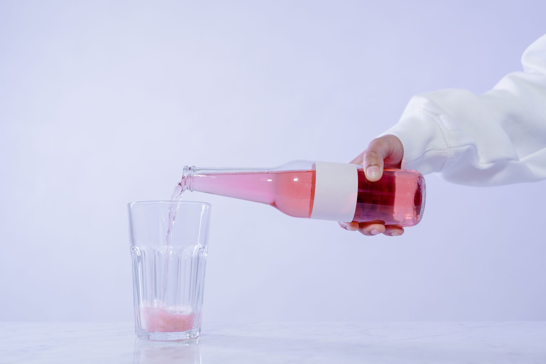 a glass of sparkling water with a slice of lemon beside a bottle of Stella Non Alcoholic, illustrating a low‑calorie, alcohol‑free alternative