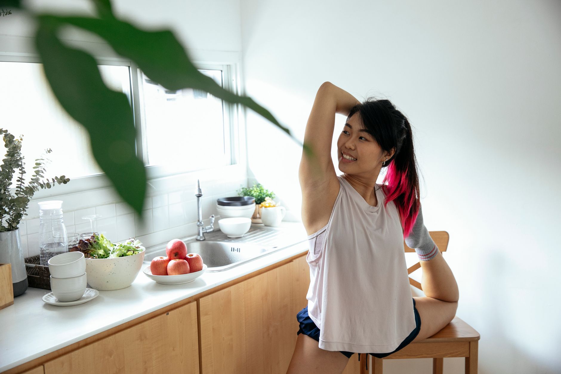 A collection of safe migraine remedies for pregnancy, including a glass of water, a magnesium supplement bottle, and a notebook of yoga poses