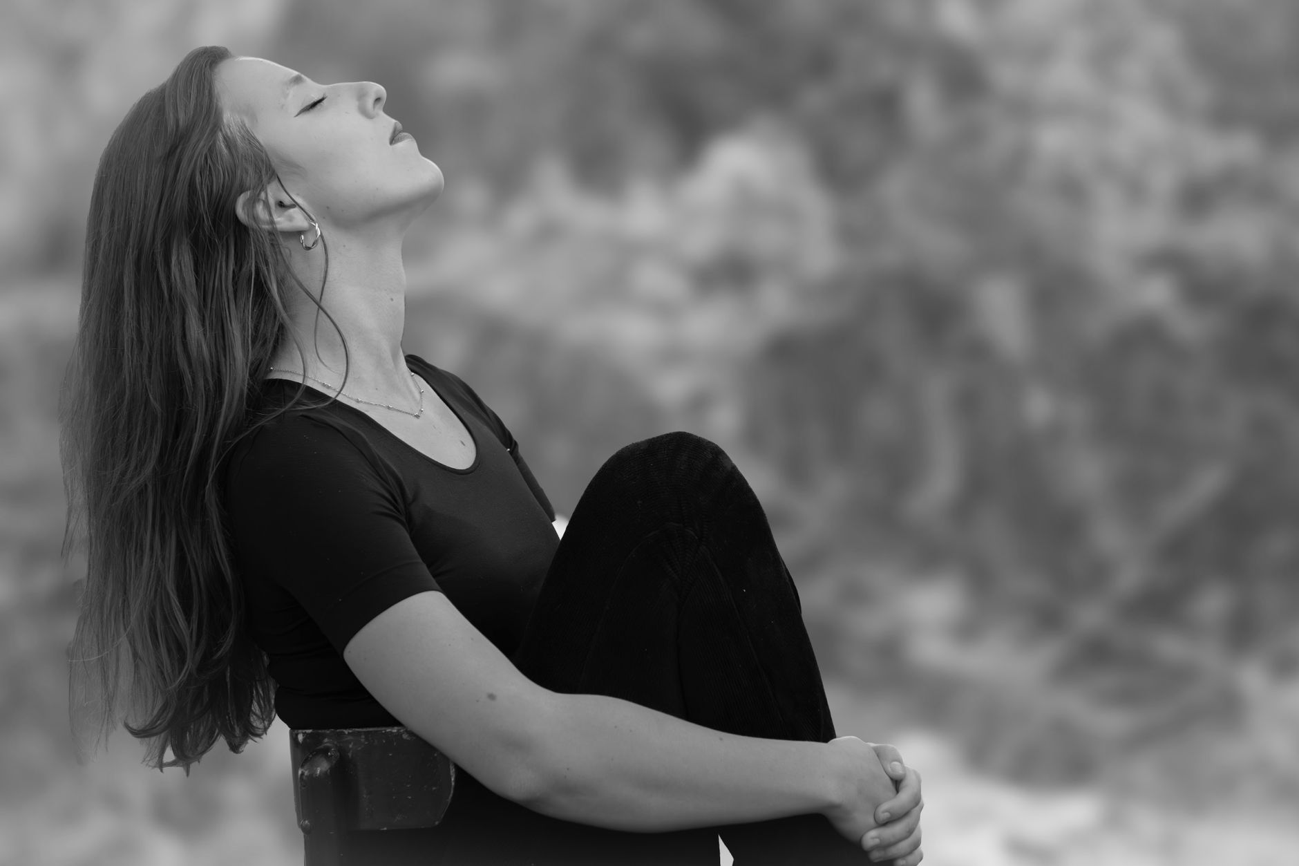 A pregnant woman taking a deep breath of fresh air outside, looking calm and relaxed, with a focus on her profile and a serene natural background.