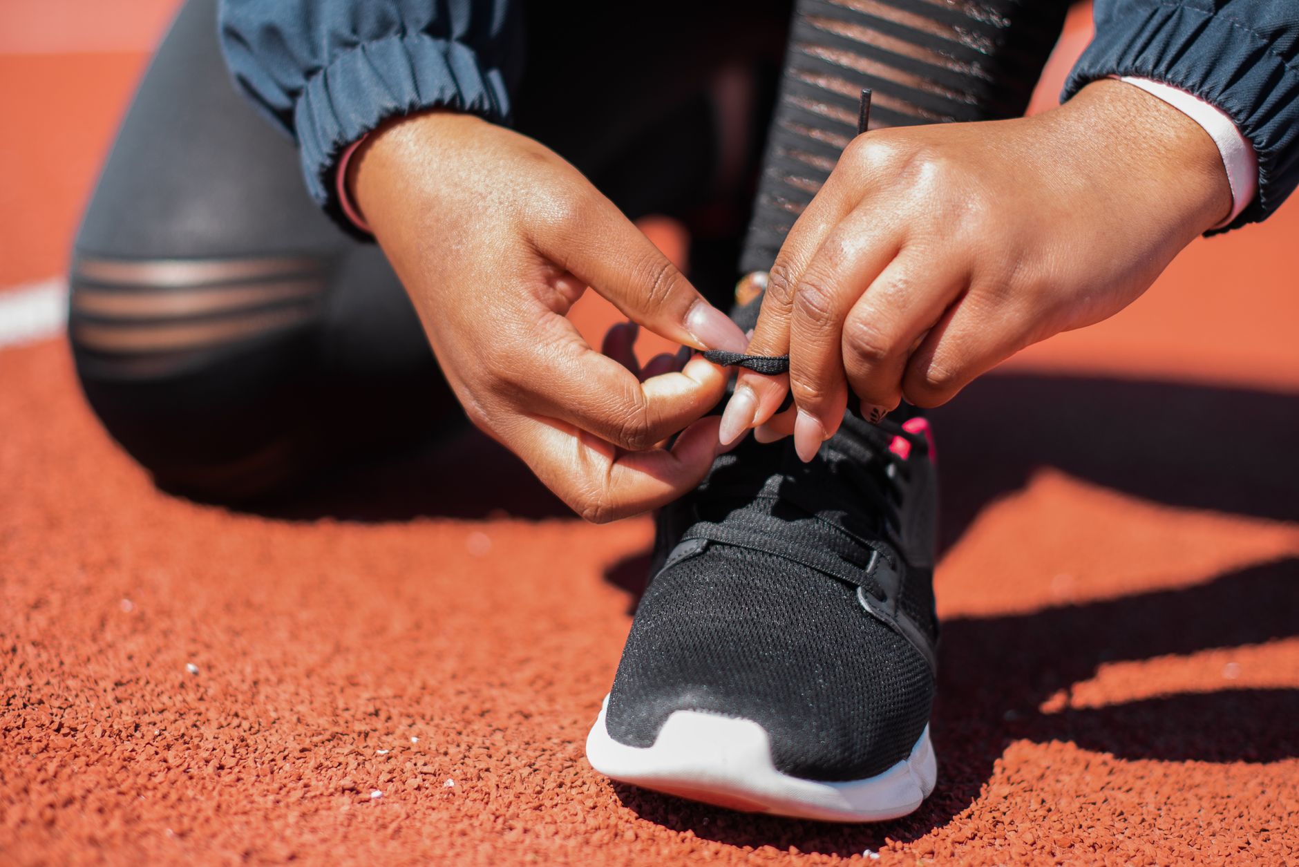 close-up of a pregnant woman tying supportive tennis shoes