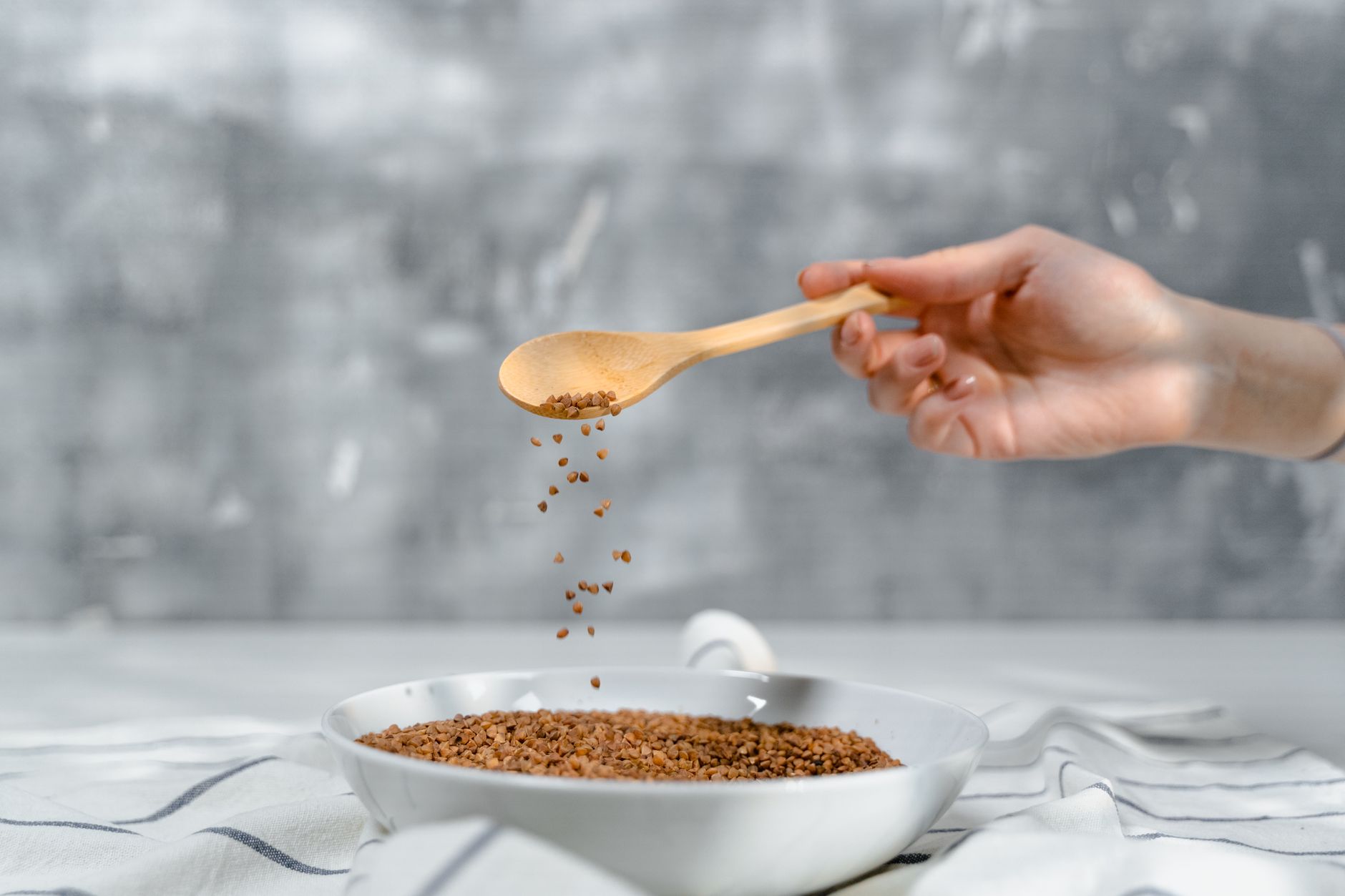 A hand holding a spoonful of Thai green curry next to a pregnancy nutrition guide, symbolizing balanced eating during pregnancy