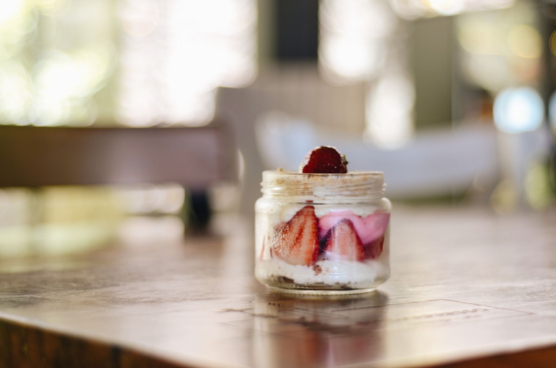 A colorful fruit parfait in a glass jar, layered with Greek yogurt, berries, and a sprinkle of cocoa, representing a pregnancy‑friendly tiramisu alternative