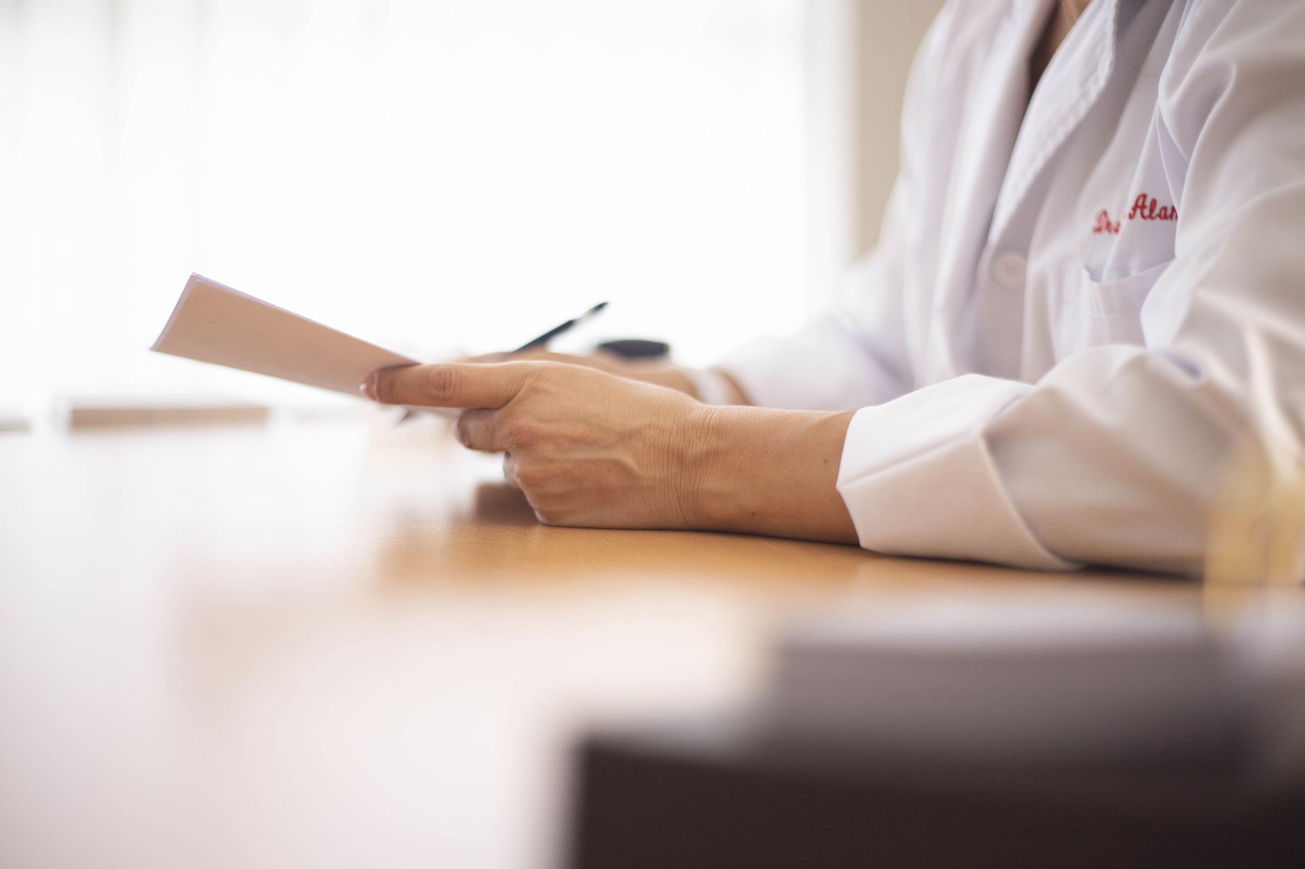 A clinician reviewing lab results on a tablet while a pregnant patient looks on, soft office lighting emphasizing a calm environment