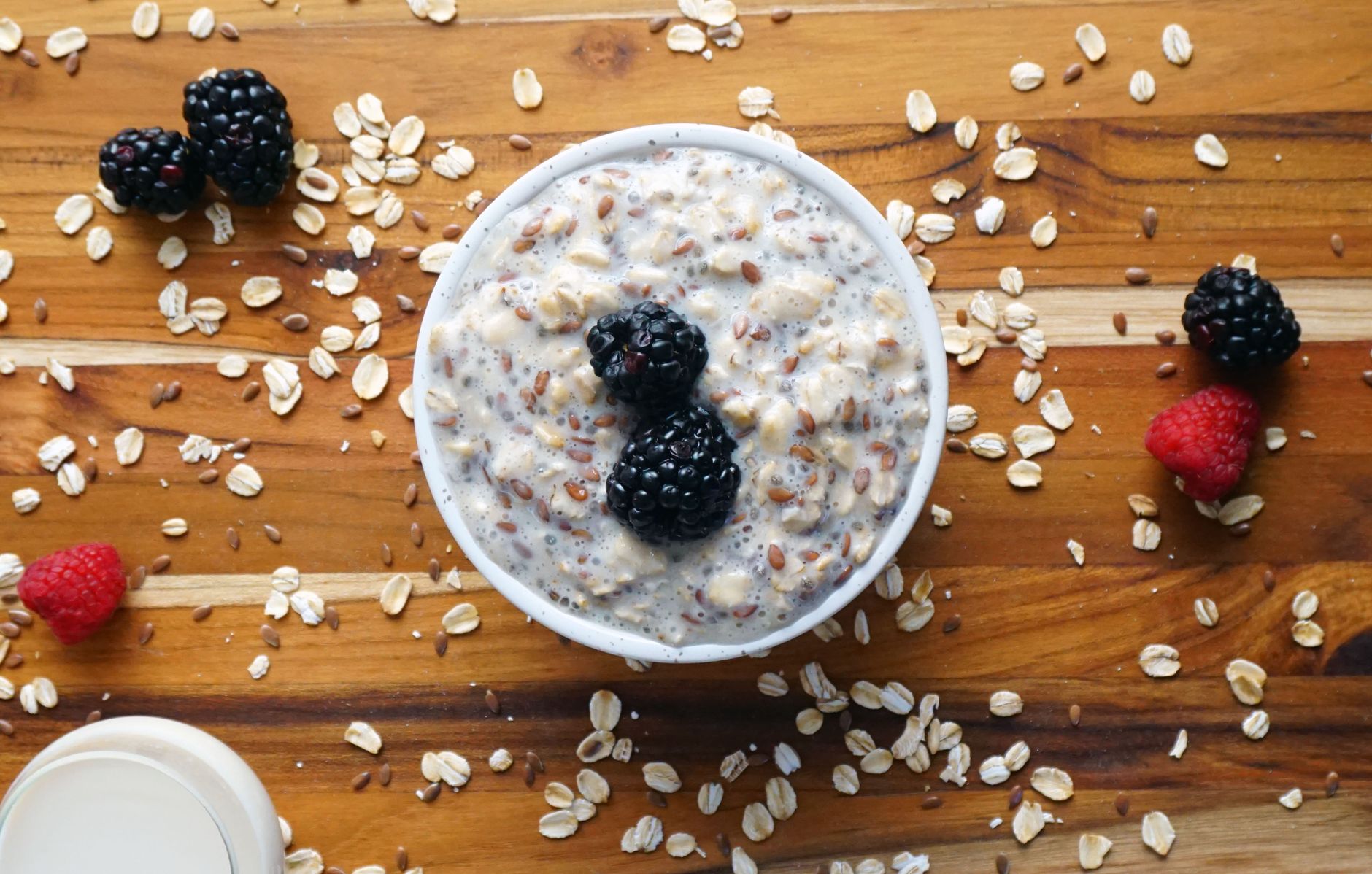 A spread of high-fiber foods like oats, apples, chia seeds, and leafy greens on a wooden table