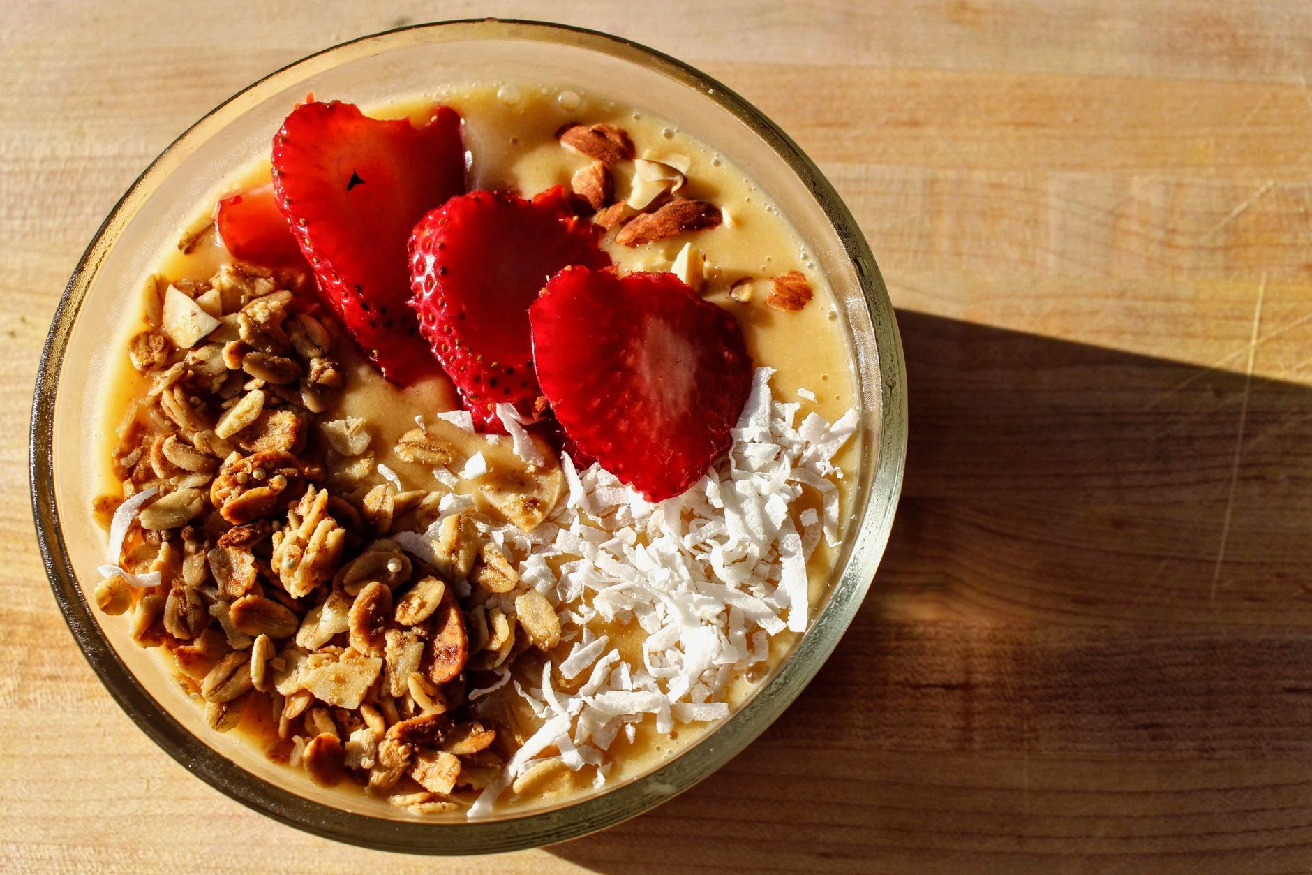 a glass of fresh orange juice beside a bowl of strawberries and a plate of red bell peppers, bright natural lighting highlighting the vibrant colors of the foods that are rich in vitamin C
