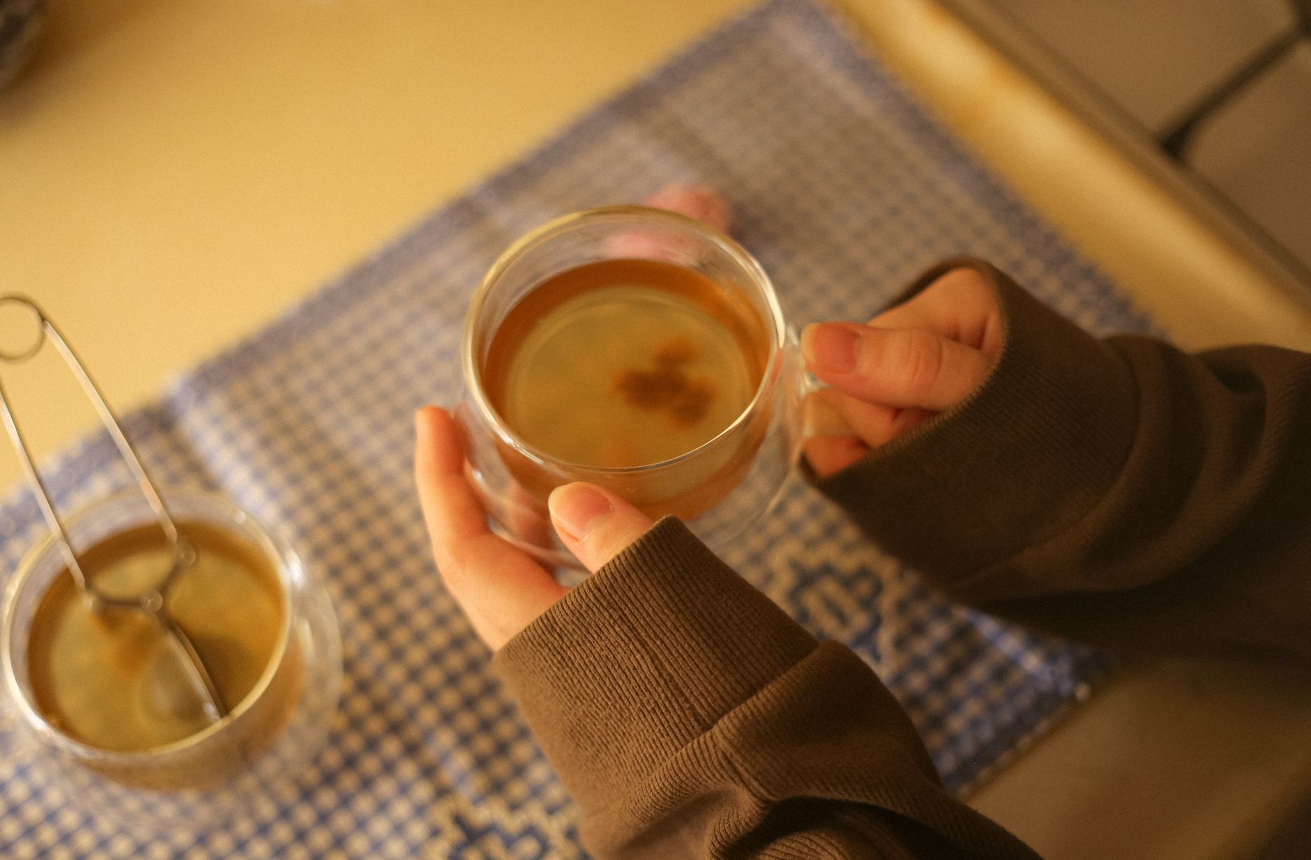 A calm evening scene with a pregnant woman holding a mug of herbal tea, a blood pressure cuff on a nearby table, illustrating mindful tea consumption for gestational hypertension