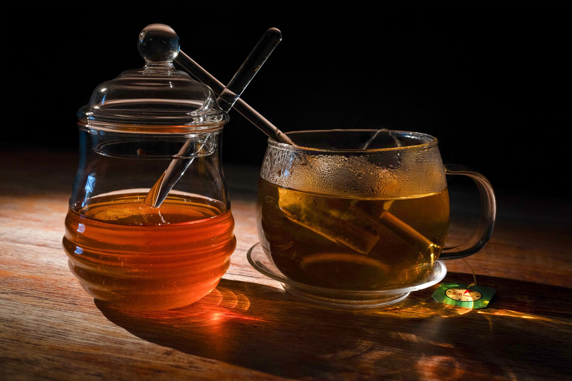 A hand holding a warm mug of honey‑lemon tea on a kitchen counter, soft daylight, comforting atmosphere