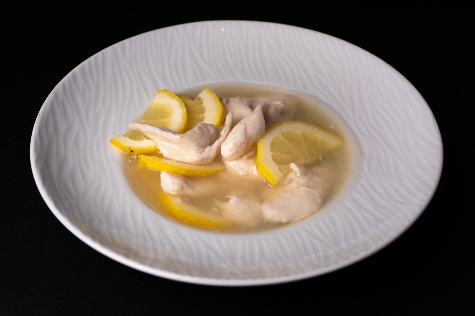 A warm bowl of chicken broth with steam rising, a slice of lemon on the side, and a small jar of vitamin C tablets beside it, soft natural lighting, realistic photorealistic composition