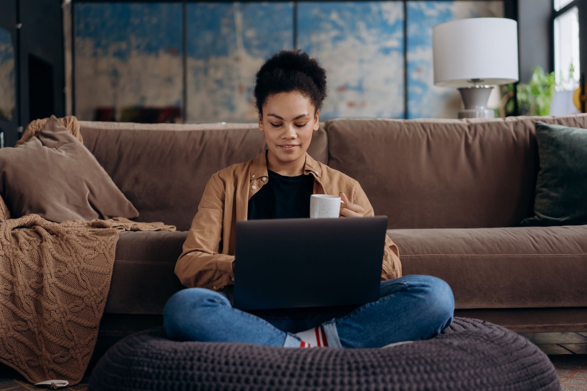 A single woman reviewing sperm donor profiles on a laptop in a cozy living room