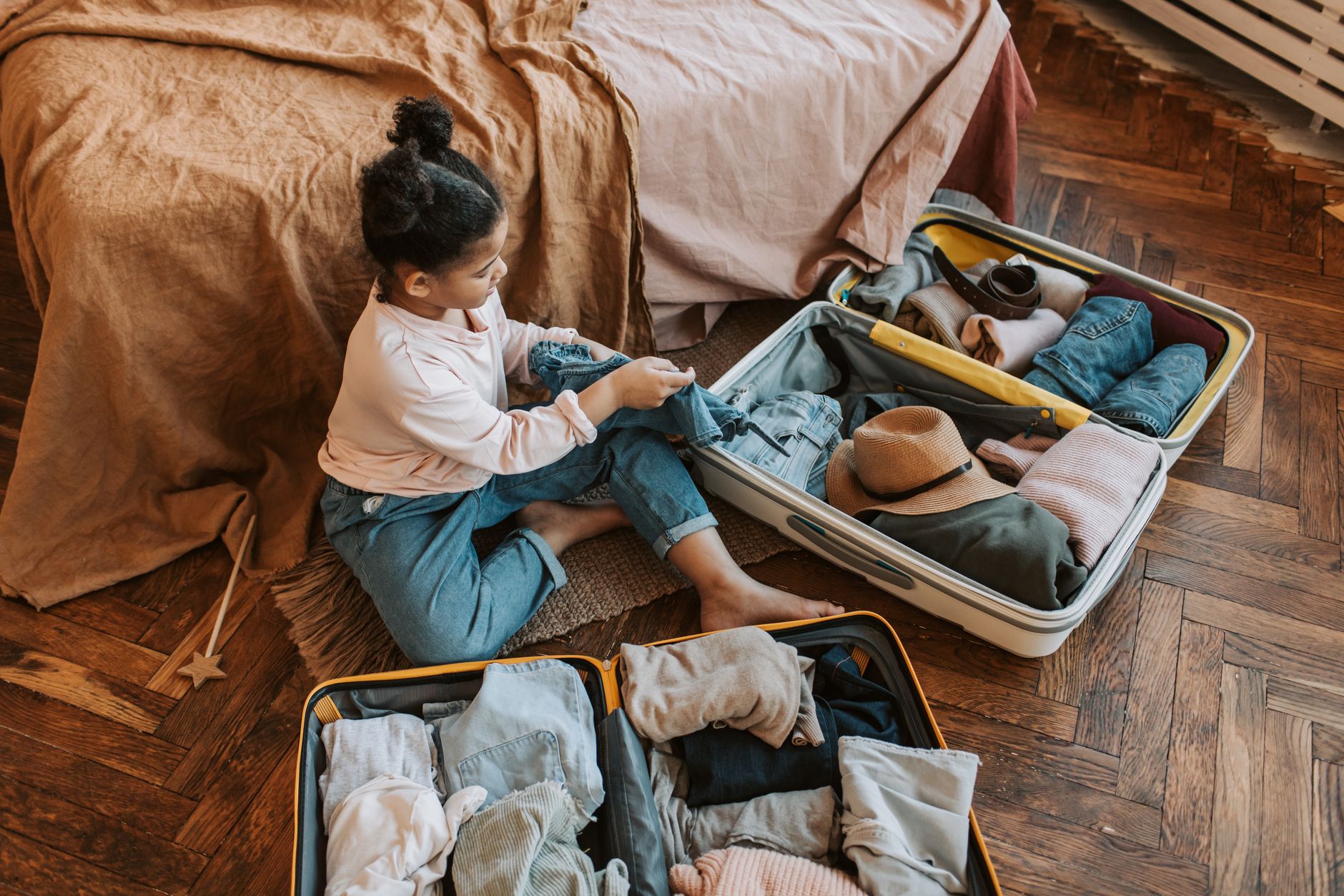 A family sitting on a tidy couch with clear bins of toys and books, smiling