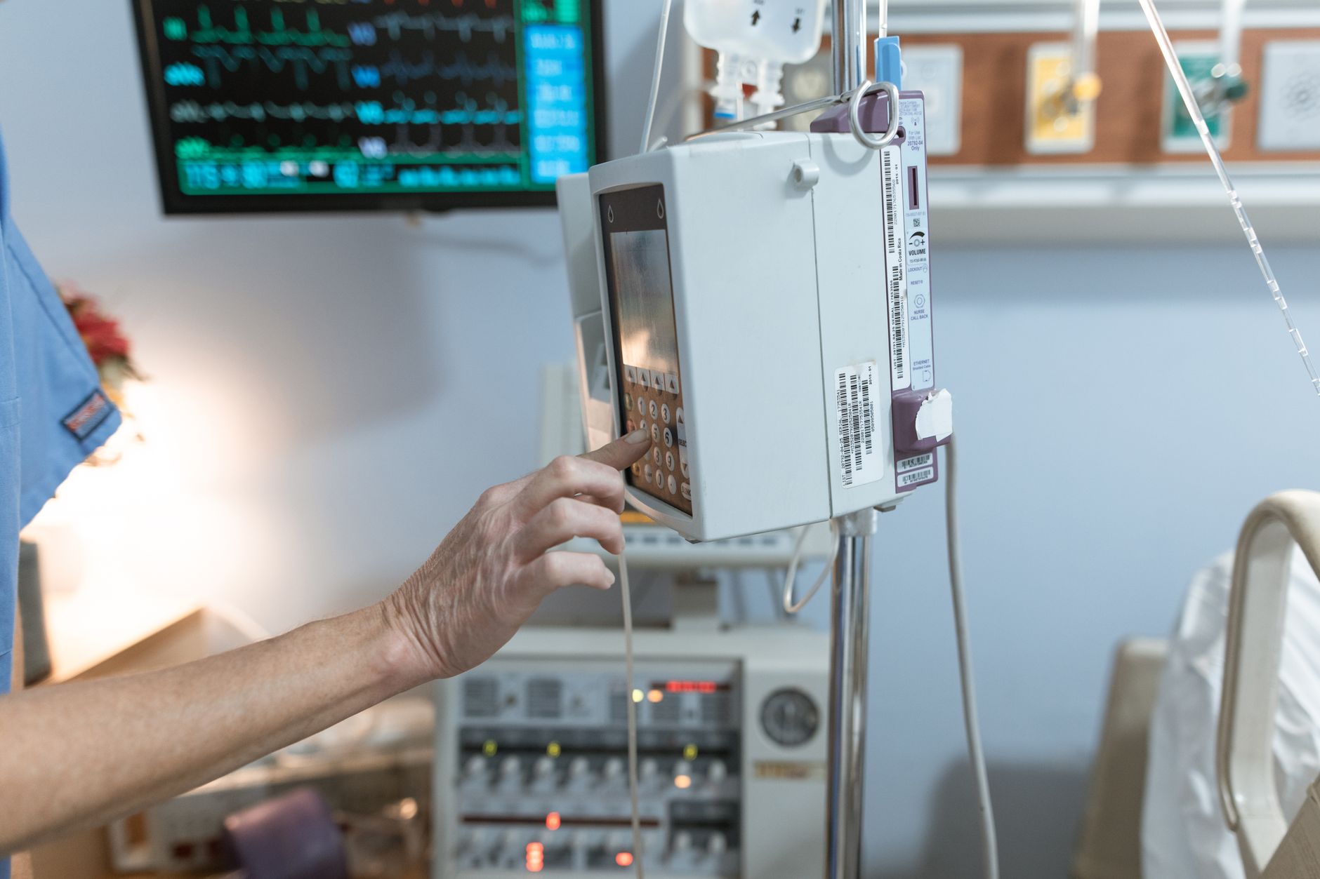 Monitoring screen showing uterine activity graph with a brief spike indicating tachysystole, alongside a nurse adjusting the infusion pump