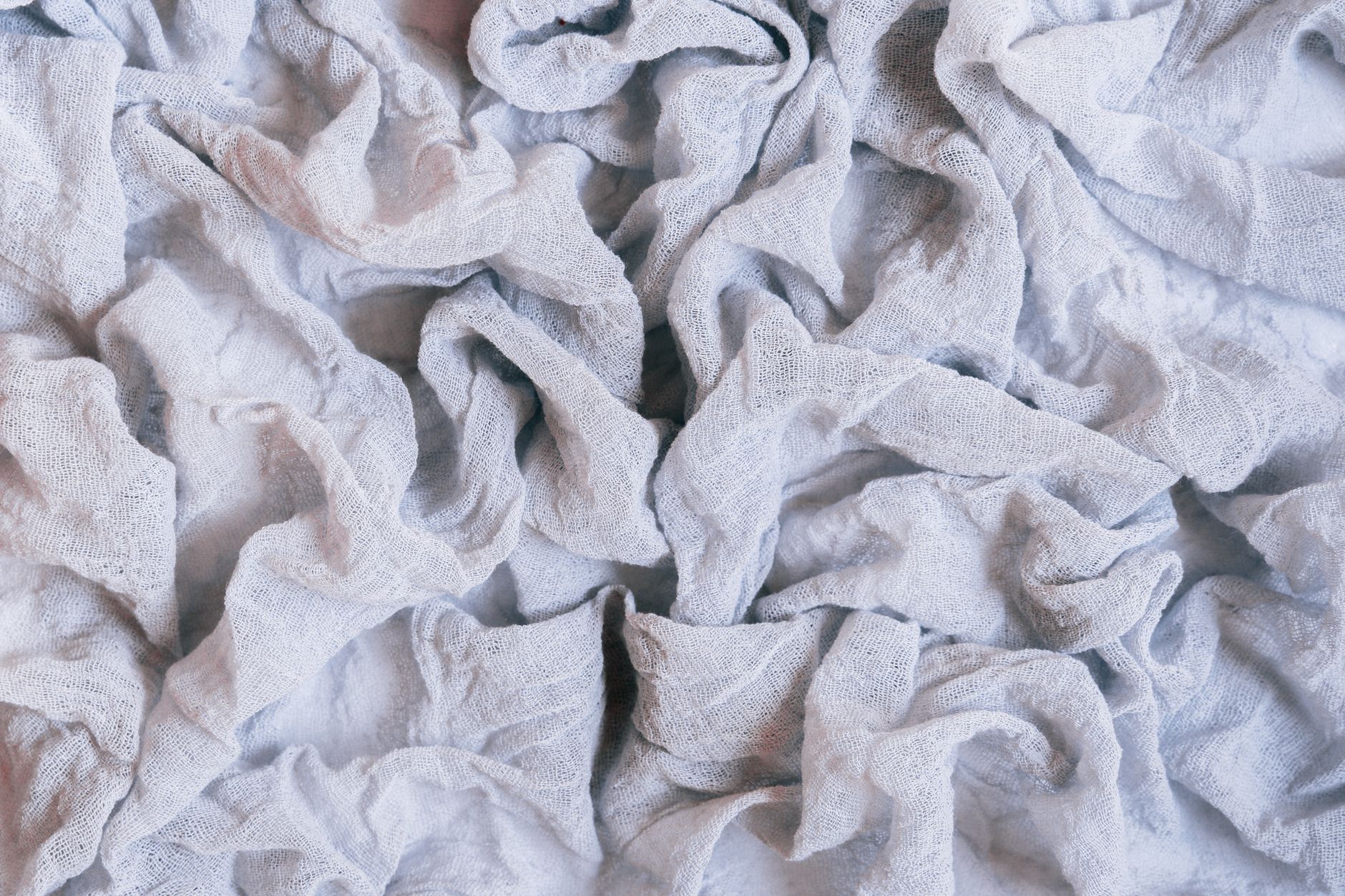 A close‑up of a freshly delivered placenta on a sterile white drape, with a hand gently holding it, illustrating the third stage of labor