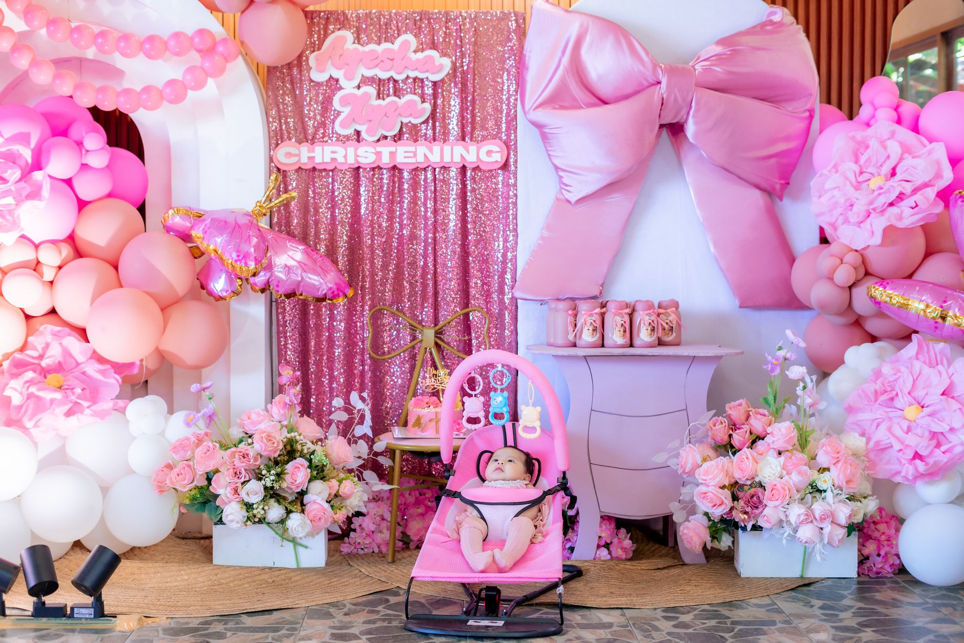 A family celebrating a baby naming ceremony with a framed name and traditional decorations