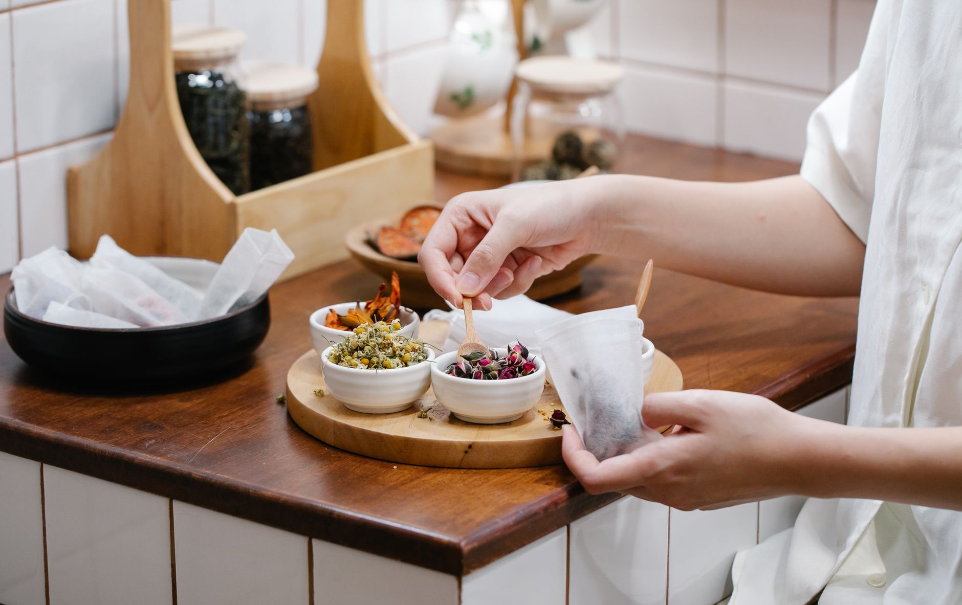 A pregnant woman sipping chamomile tea while surrounded by fresh fruits and herbs