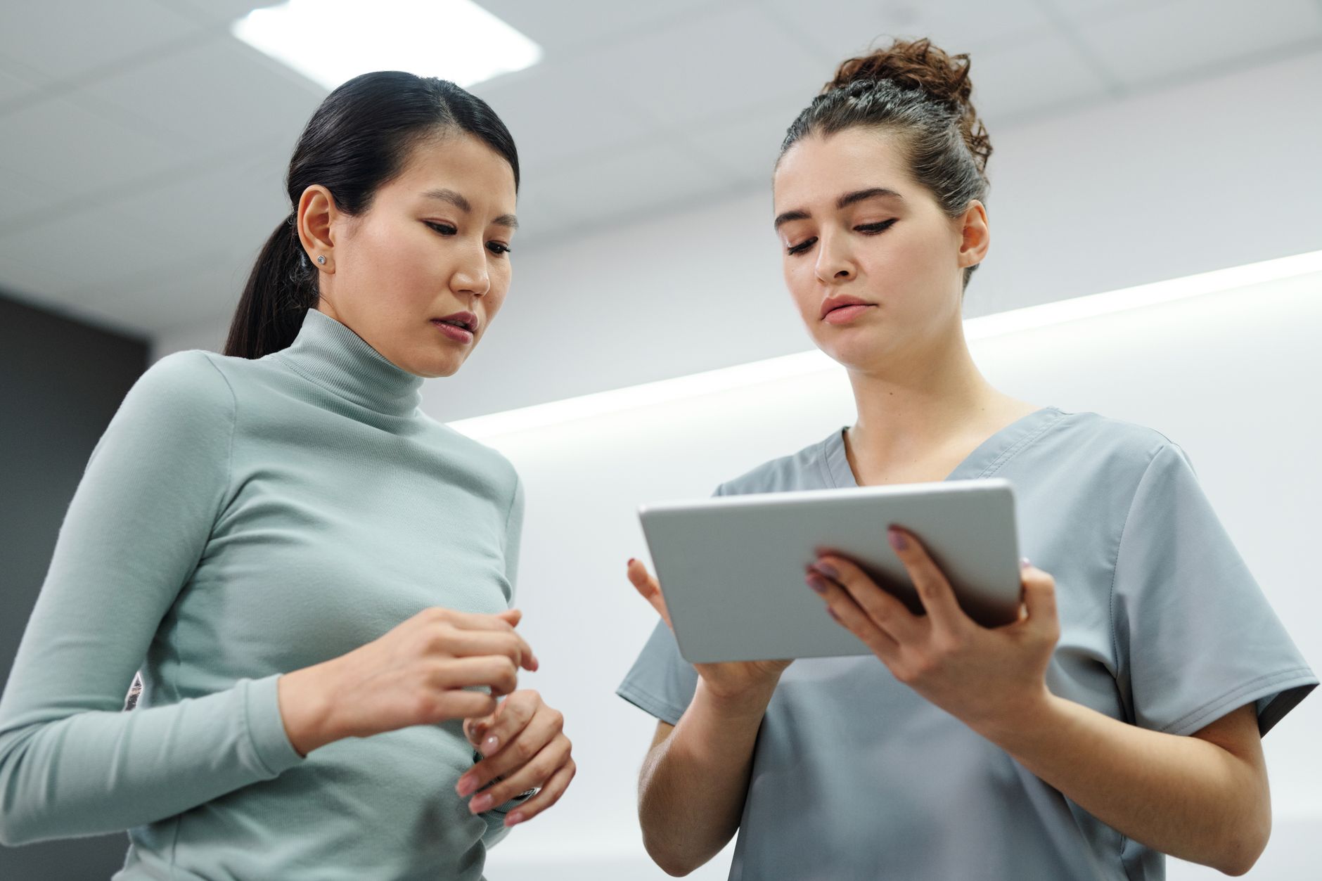 A doctor explaining lab results to a pregnant woman in a bright, modern clinic setting