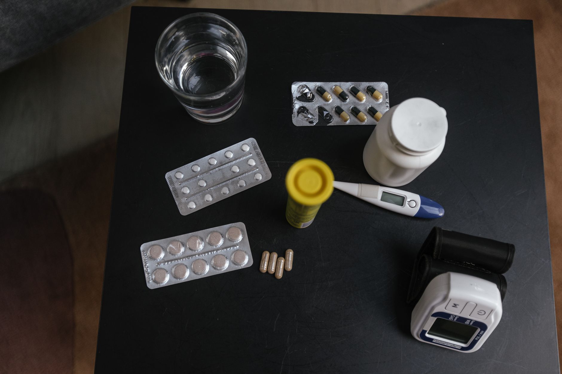 A glass of water next to a pair of cotton underwear and a probiotic supplement bottle