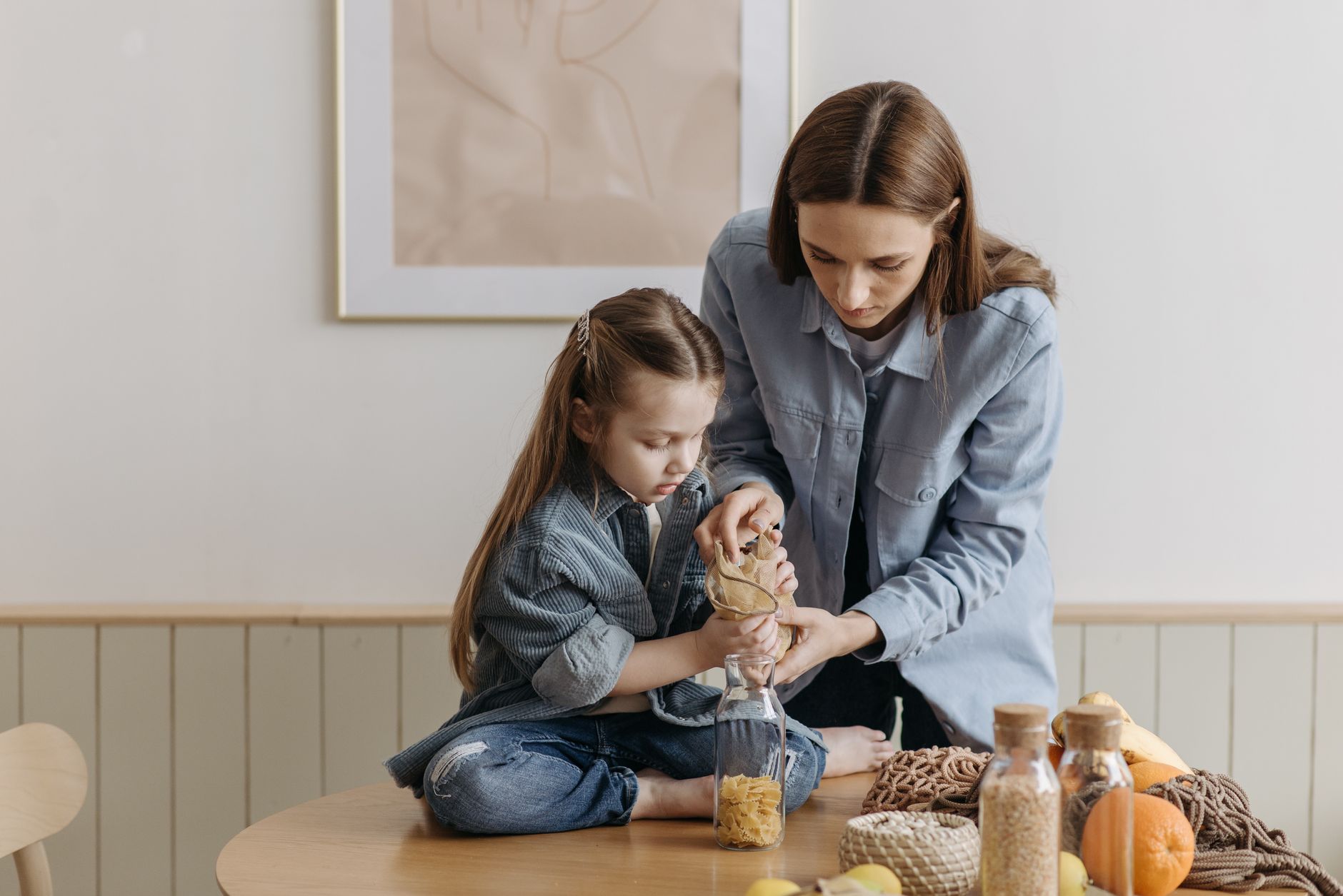 Children helping to fill reusable containers with pre‑cooked meals in a bright kitchen