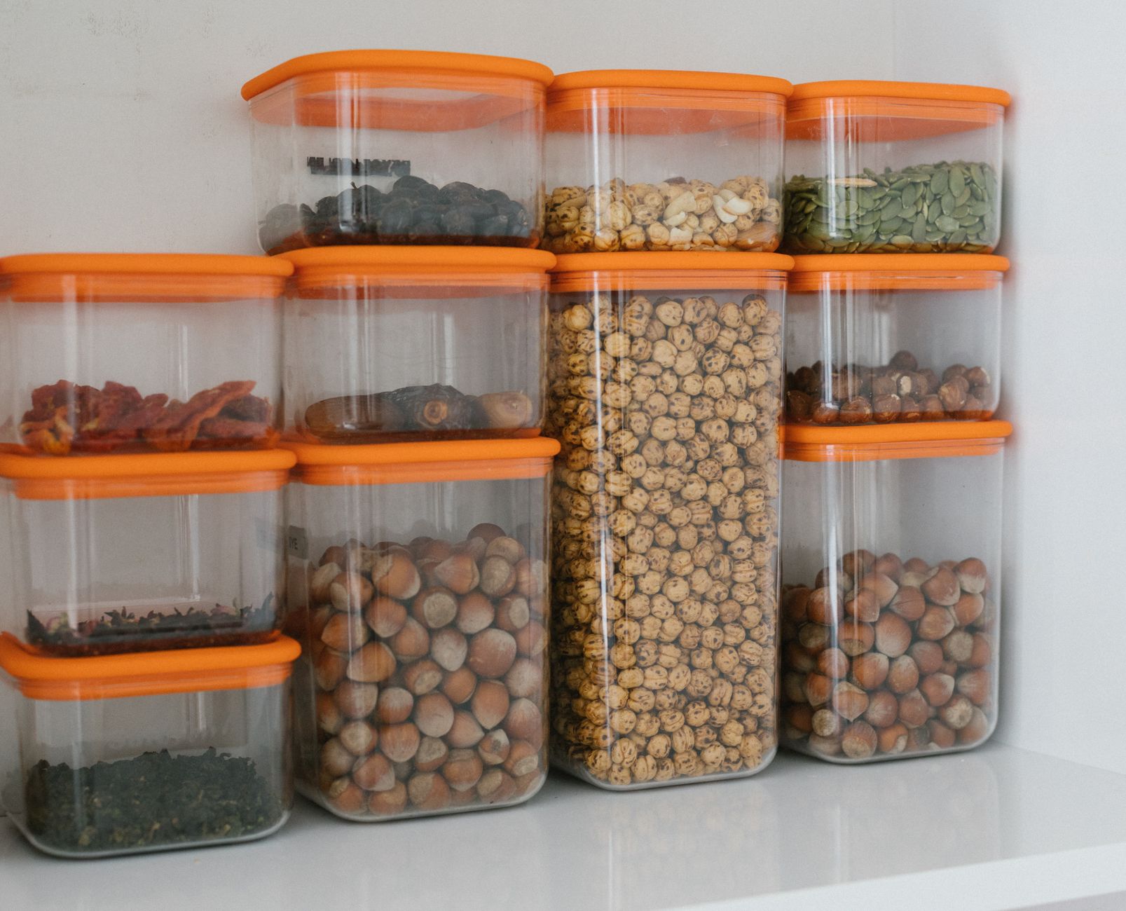 Stacked meal prep containers with labeled lids on a kitchen counter